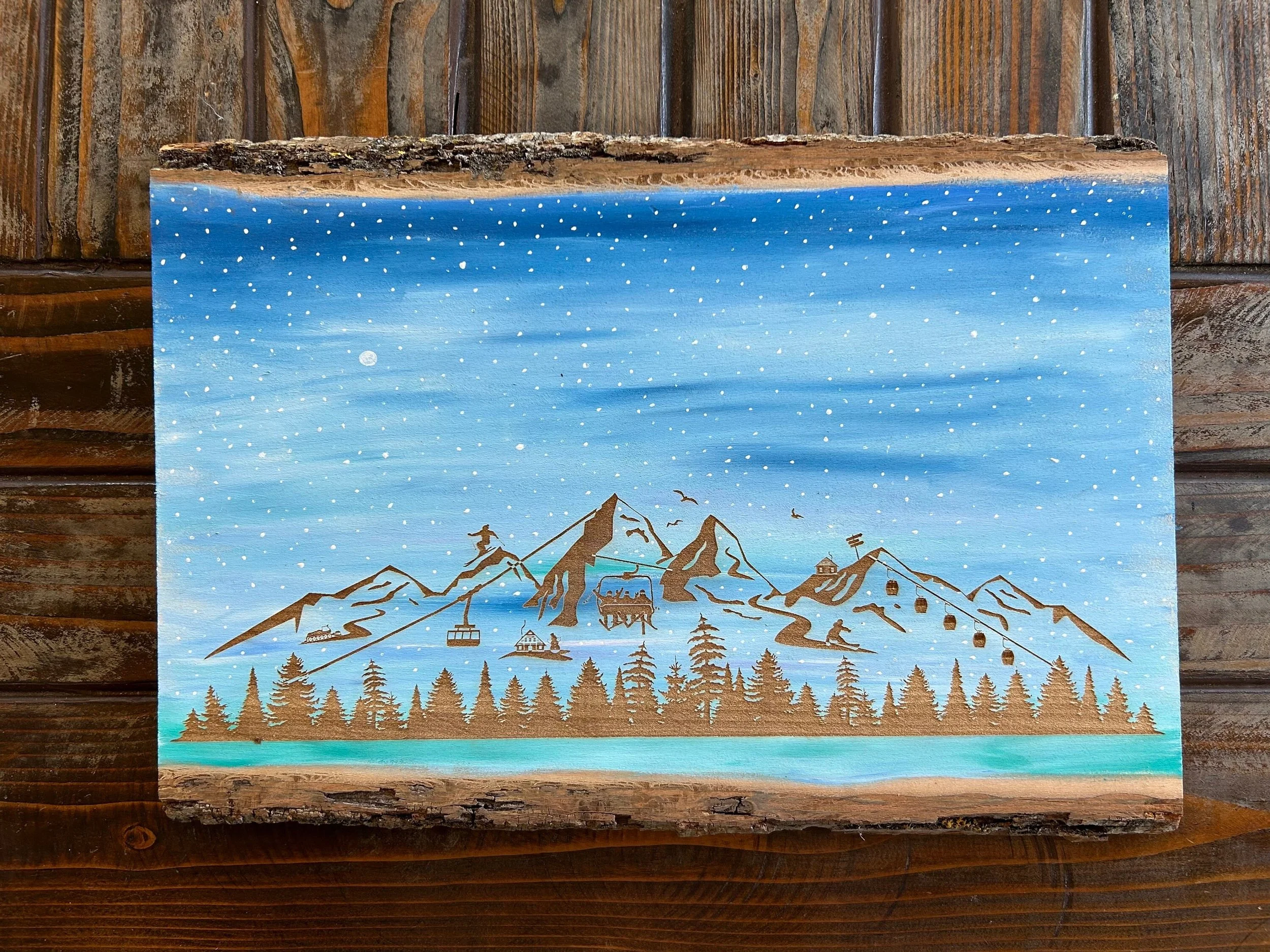 Painting of a mountain landscape with trees, a lake, ski lifts, and small buildings under a snowy sky with a full moon.