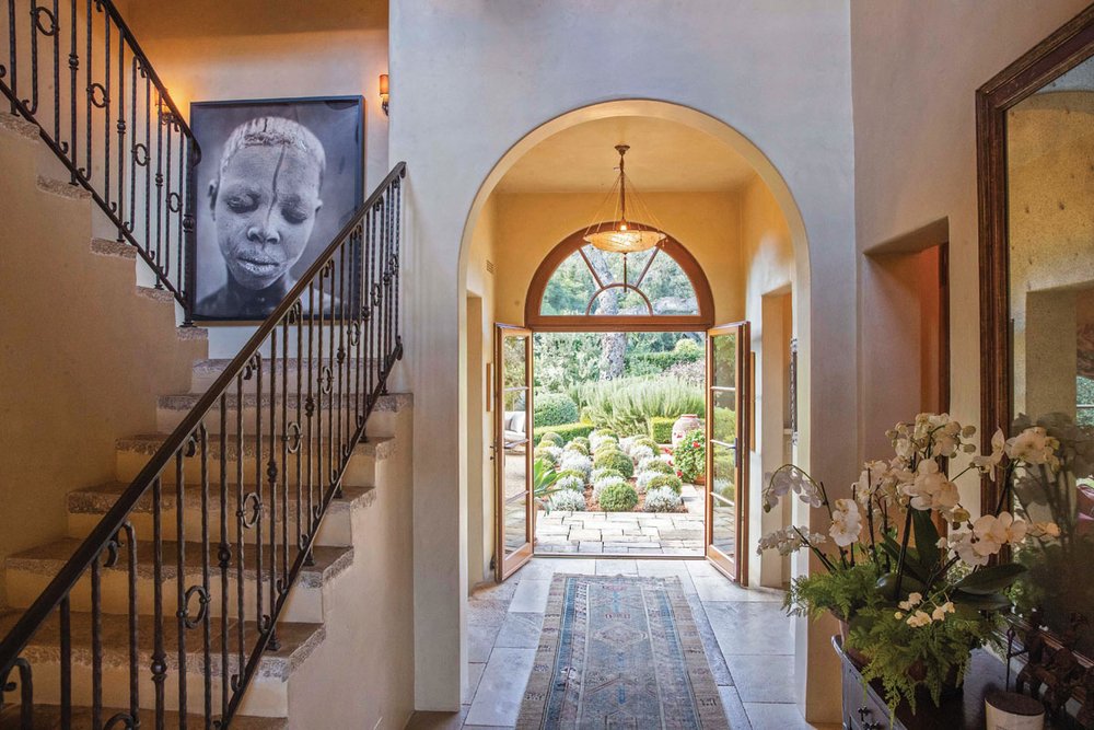  The serene entryway is punctuated by a grand staircase topped by a dramatic black-and-white photograph by Spanish photographer Isabel Muñoz. 