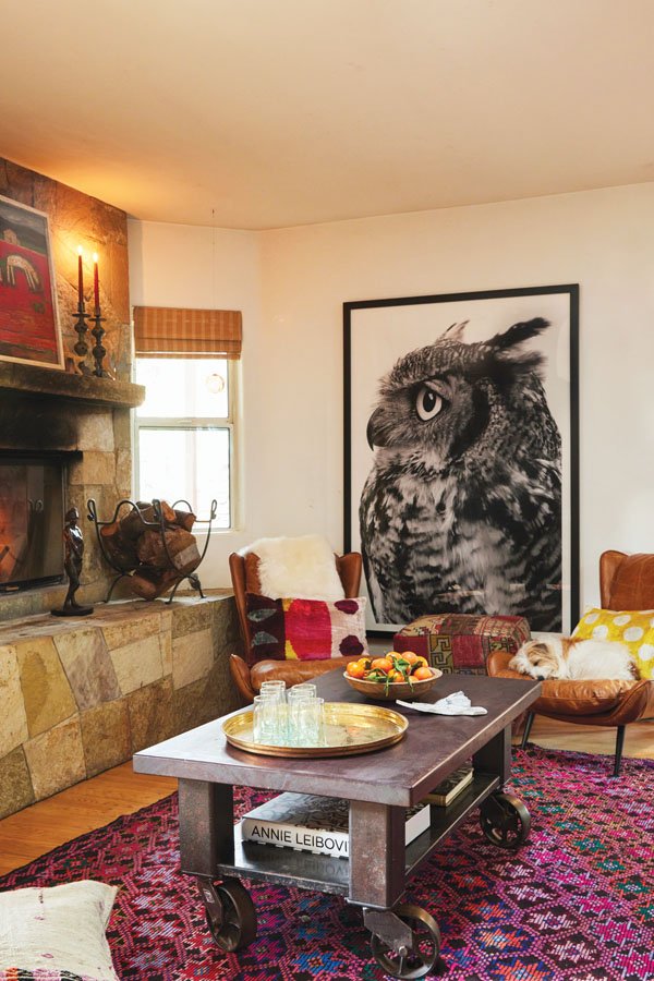  A large-scale owl print by MaHarry’s sister, Jennifer, anchors vintage leather chairs by DeKor in Ojai; a steel table handmade by MaHarry and her husband, Patrick Henderson; a stone fireplace, topped with a sculpture crafted by MaHarry’s father. 