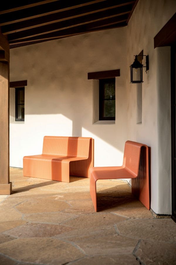  Minimalist metal “ribbon” benches by Laun provide seating under the home’s generous veranda. 