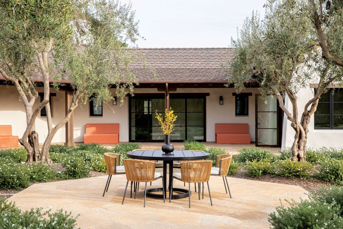  A round table from Restoration Hardware is surrounded by Ligne Roset chairs. 