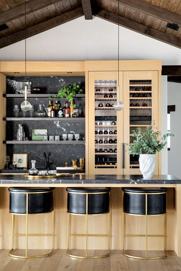  The sleek bar is well equipped for festive libations; bar stools by Restoration Hardware. 