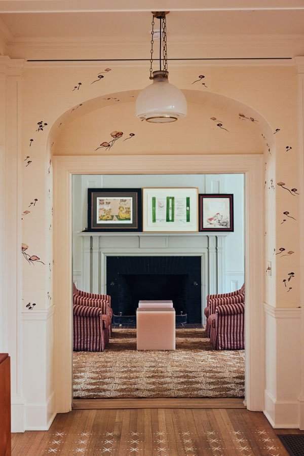  Maison C’s Myco wallpaper lines the entry; Dr. Seuss drawings on the mantel, striped Melrose armchairs, Sabine Marcelis’ polished resin Candy Cubes, and a seagrass rug. 