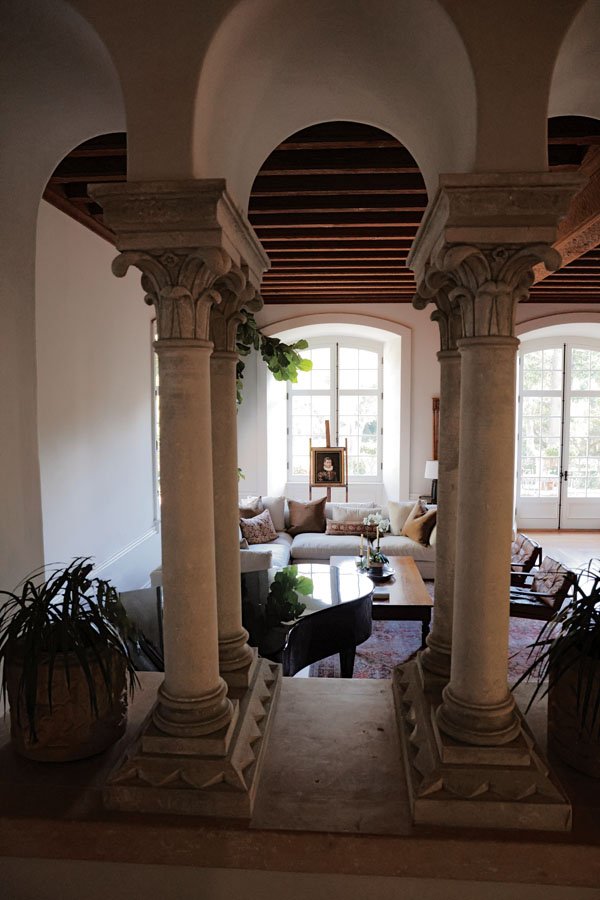  Classical columns flank the great room, which is lined with French doors leading to the formal garden. 