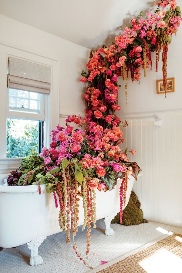  Bounteous blooms filled every space of a 19th-century residence during a fundraiser at Rose Story Farm that also showcased the work of designers. In the upstairs bath the flowers rose toward the ceiling and cascaded over the tub in an installation b