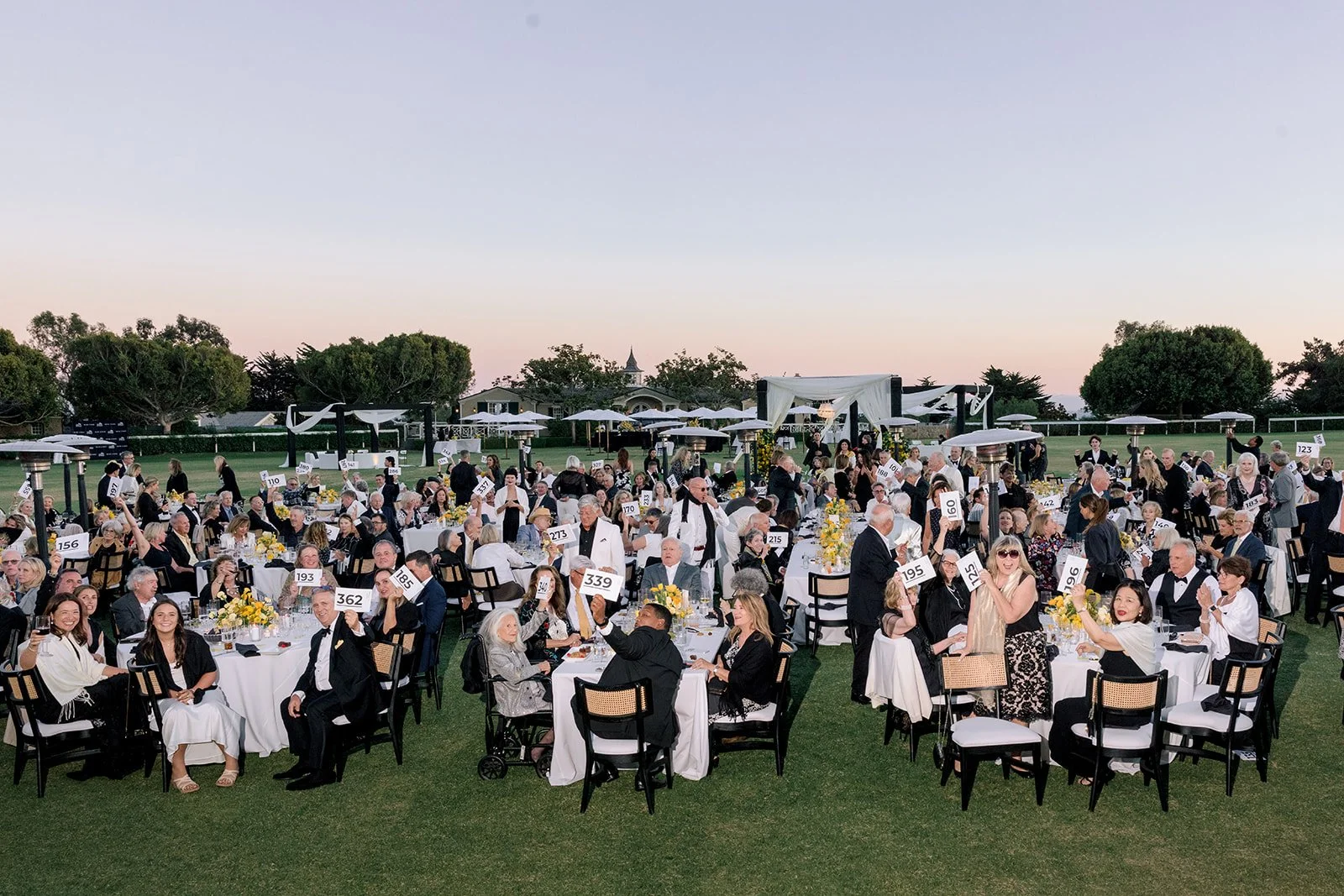  Guests raise their paddles during the fund-a-need at the 2026 Music Note Gala, the Music Academy of the West's premier fundraising event, supporting full scholarships for every fellow and expanding access to music education throughout the community.