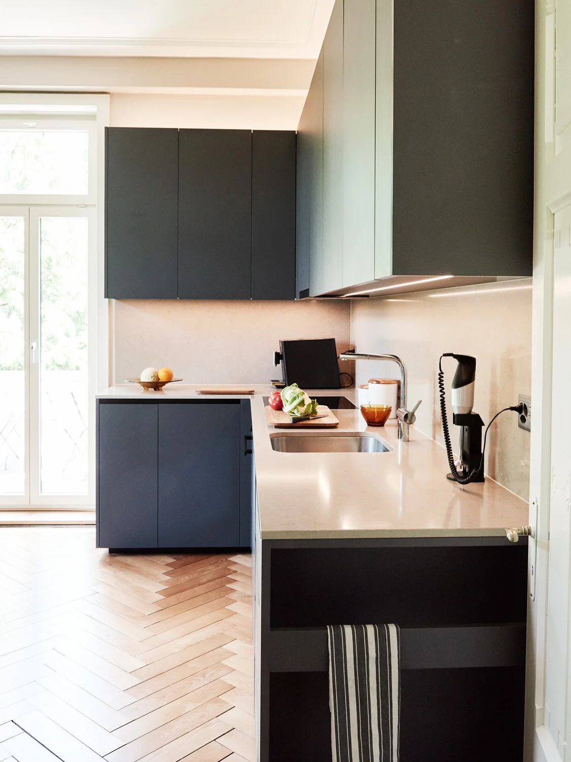 Schwarze Küche mit altem Parkettboden, Apartment Zollikon