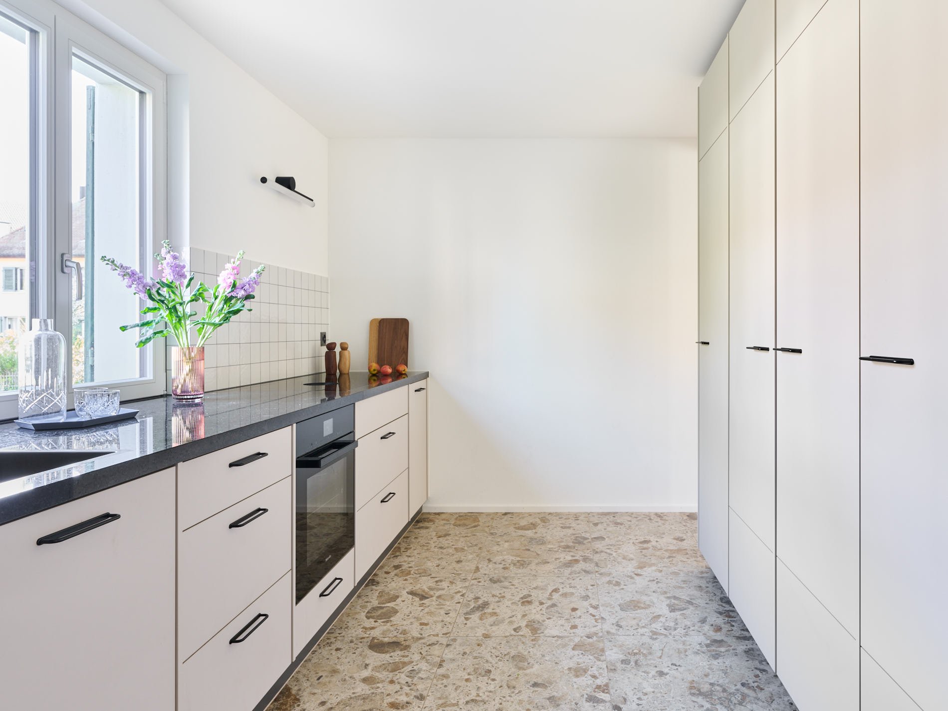 Küche mit viel Licht und Durchgang ins Wohnzimmer, Privathaus Zürich