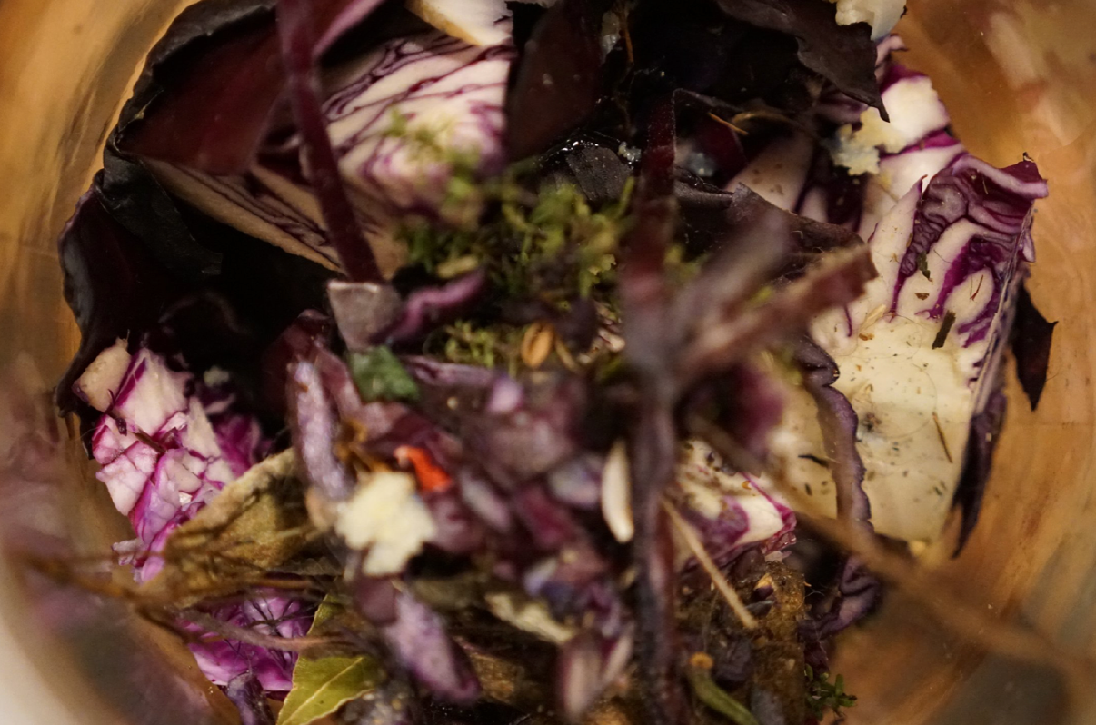  A close up of a chopped red cabbage in a bowl, mixed together with other leaves and vegetables 