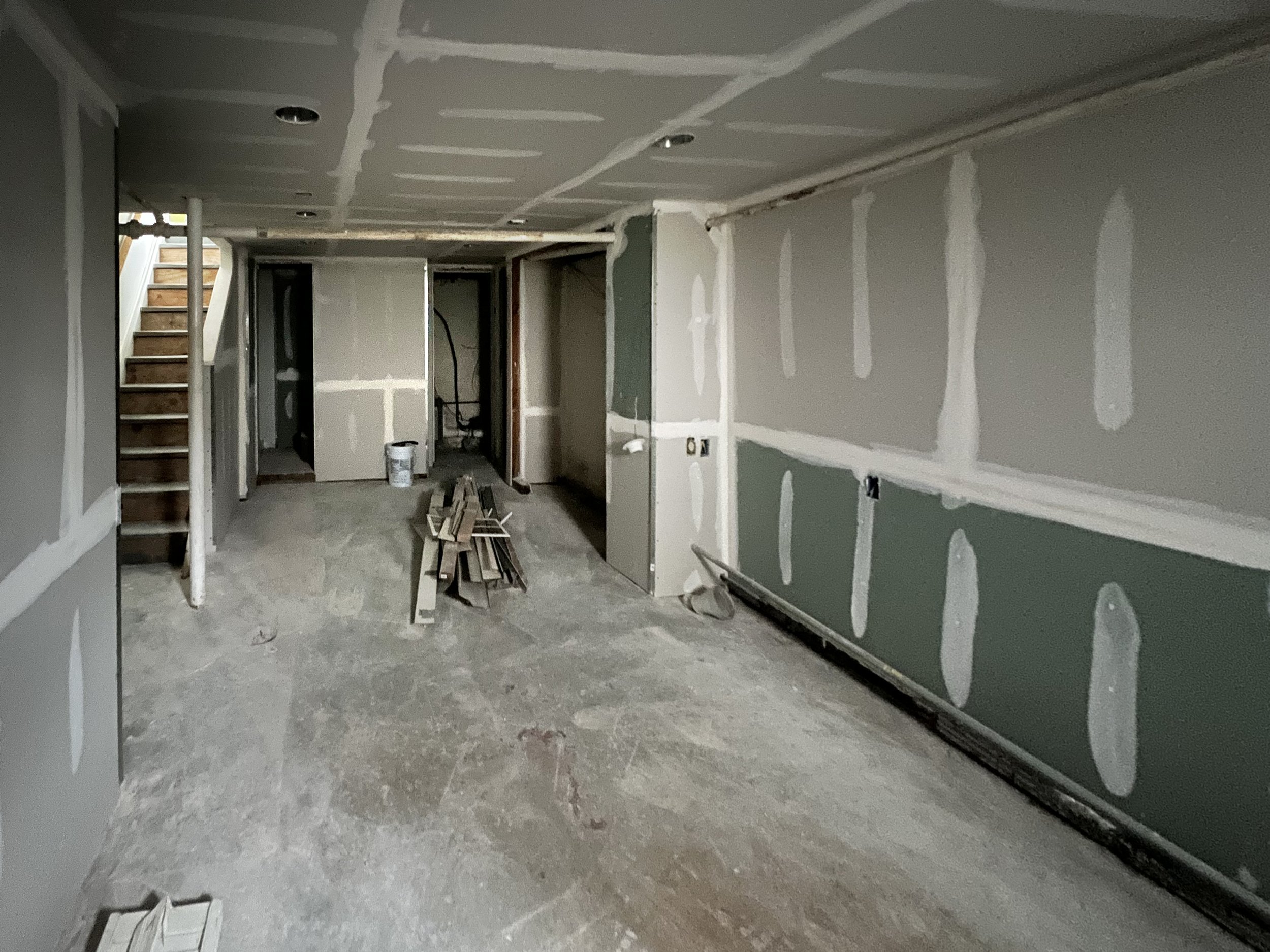 Interior of a house under construction with drywall installed and unfinished floors.