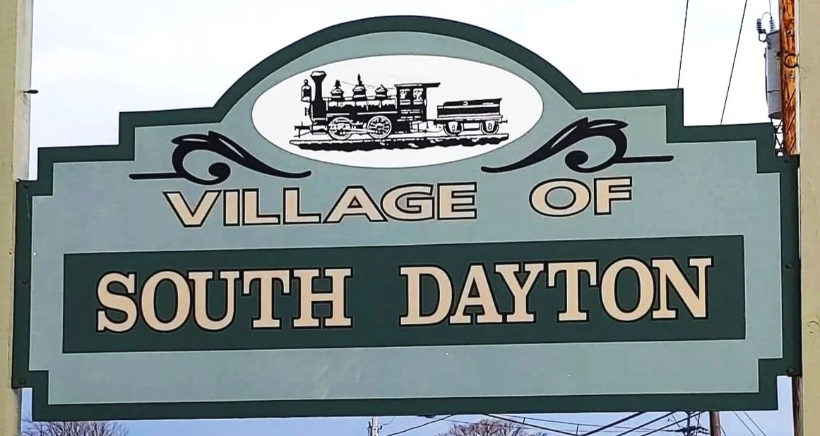 Sign reading 'Village of South Dayton' with a train illustration at the top.