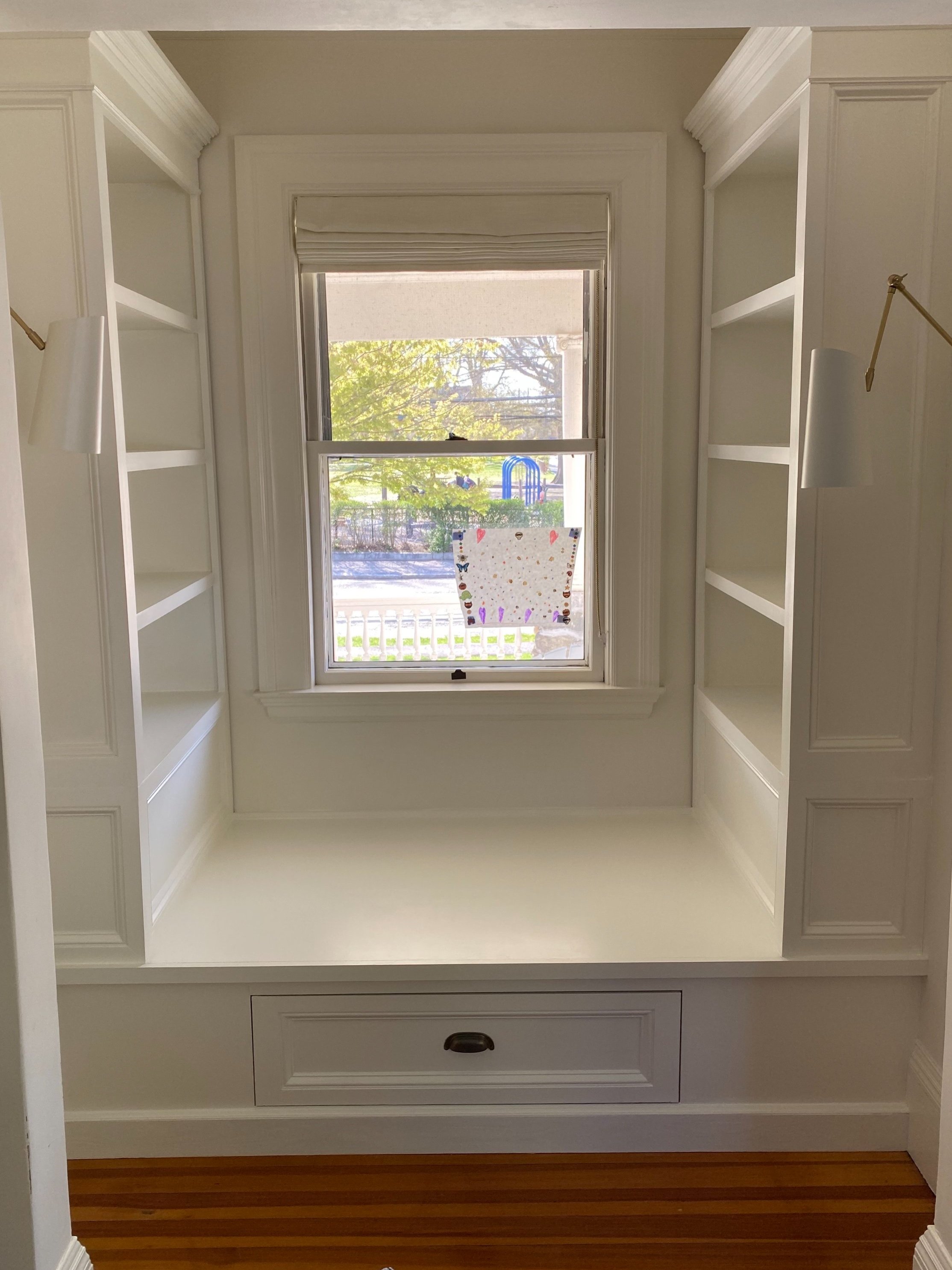 A massive window seat with matching shelving in a cozy alcove.