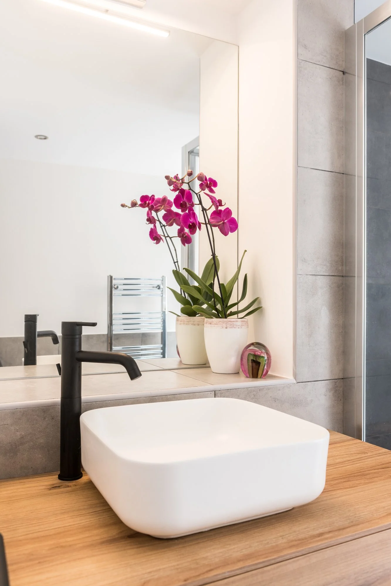 Nel progetto Bi-Cubo anche gli ambienti di servizio partecipano alla costruzione dell'identità architettonica dell'abitazione. Il bagno è concepito come uno spazio essenziale nel quale la composizione si fonda sul dialogo tra materiali, proporzioni e