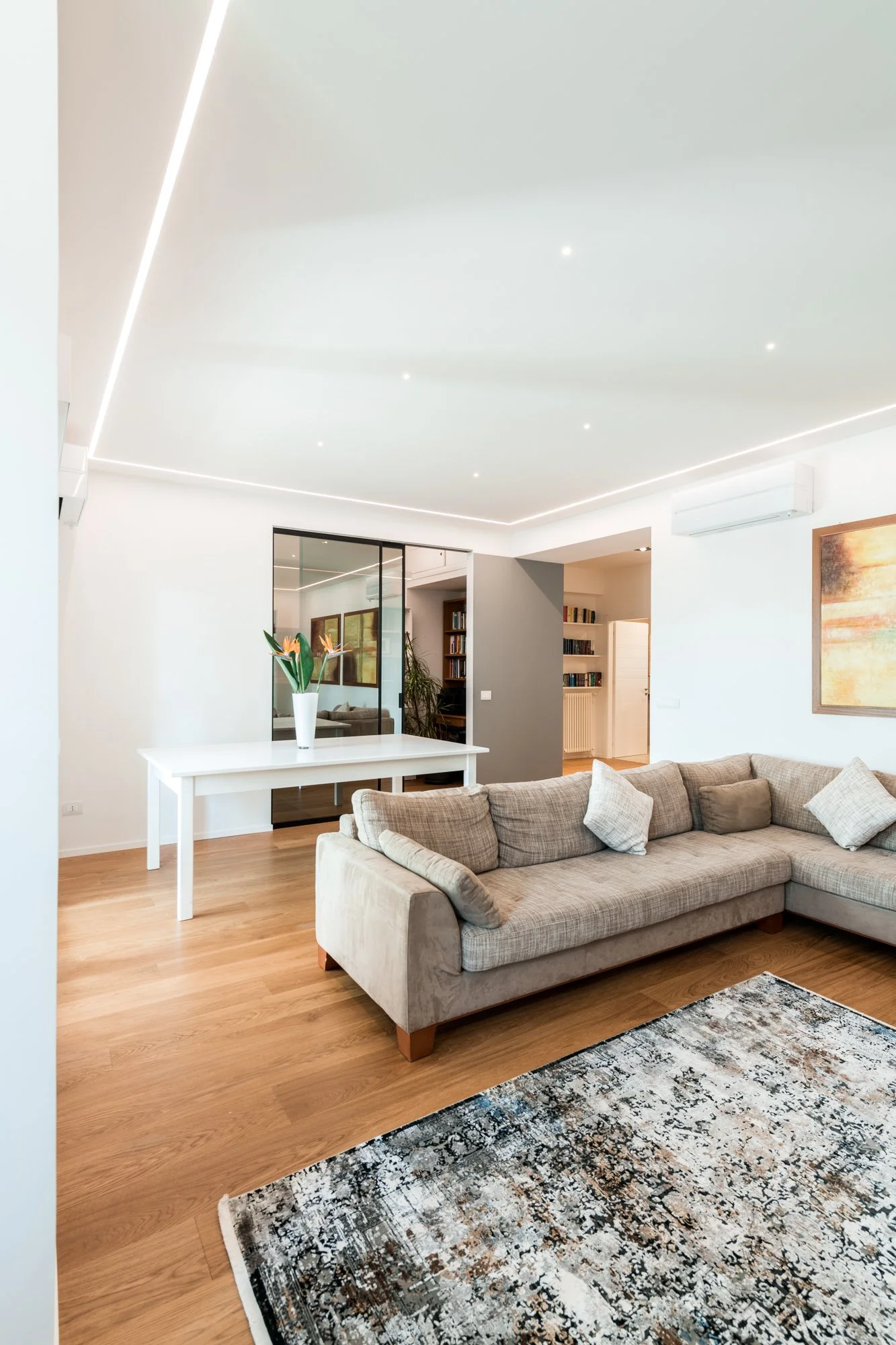 La zona giorno dialoga con lo studio attraverso una vetrata scorrevole che amplia la percezione dello spazio. Nel progetto Mikado a Palermo, luce naturale, parquet in rovere e relazioni visive costruiscono un ambiente domestico fluido e contemporaneo