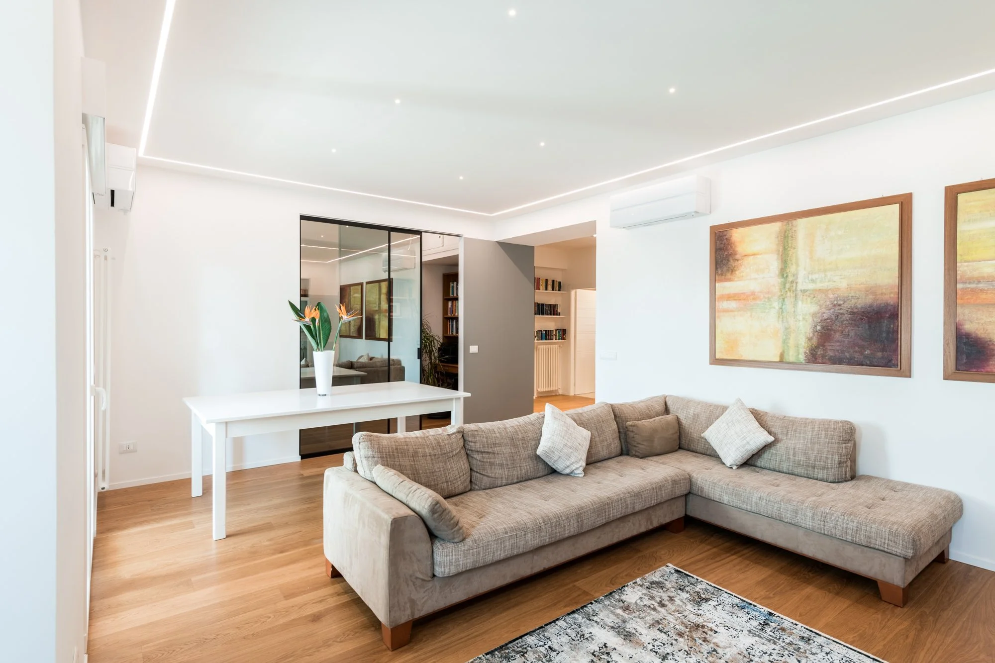 La zona giorno dialoga con lo studio attraverso una vetrata scorrevole che amplia la percezione dello spazio. Nel progetto Mikado a Palermo, luce naturale, parquet in rovere e relazioni visive costruiscono un ambiente domestico fluido e contemporaneo