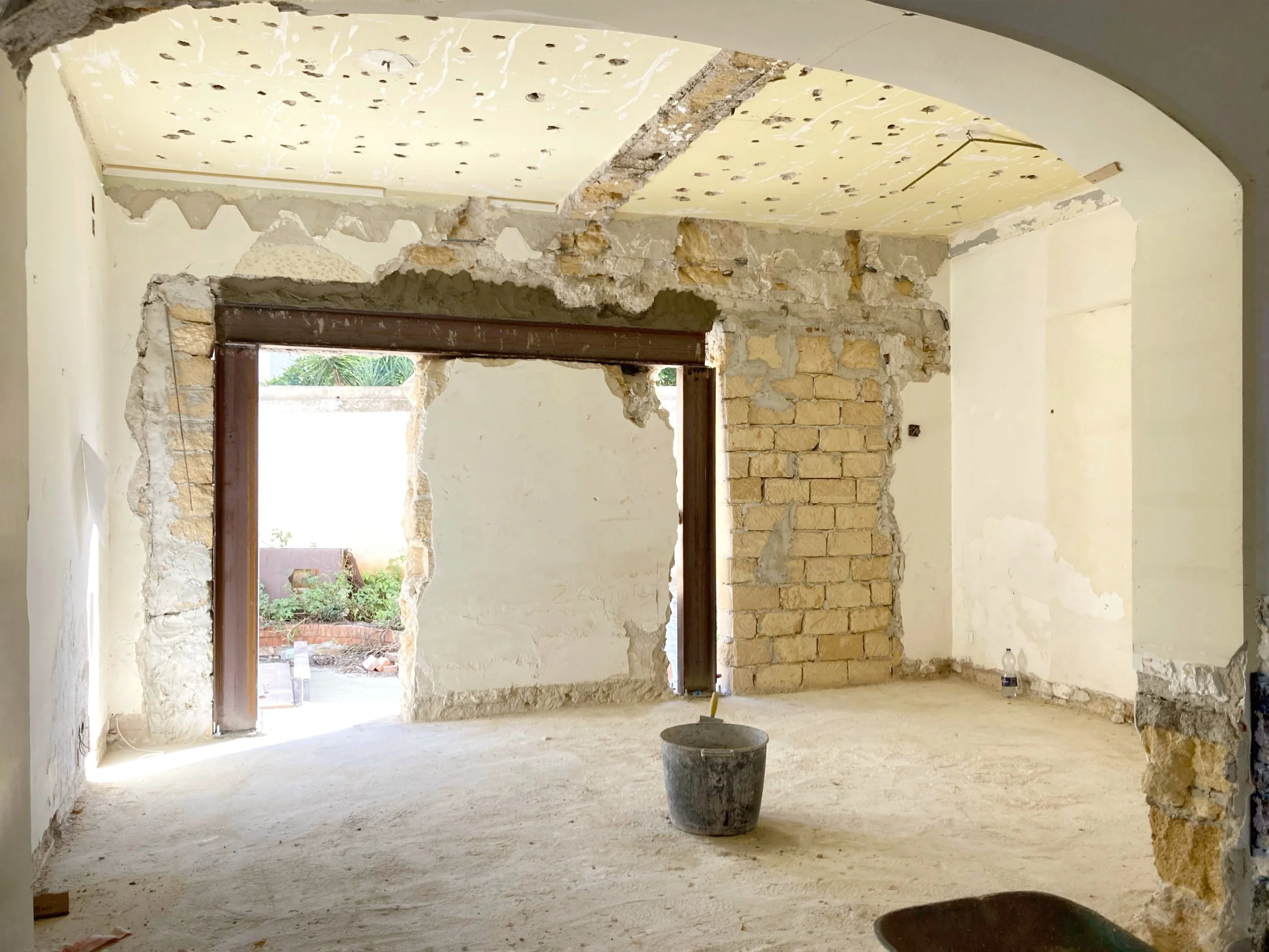 Fase di cantiere dedicata alla realizzazione della nuova cerchiatura strutturale che consente di ampliare l'apertura tra soggiorno e cucina. La foto è scattata durante la realizzazione della cerchiatura strutturale durante la trasformazione di una vi