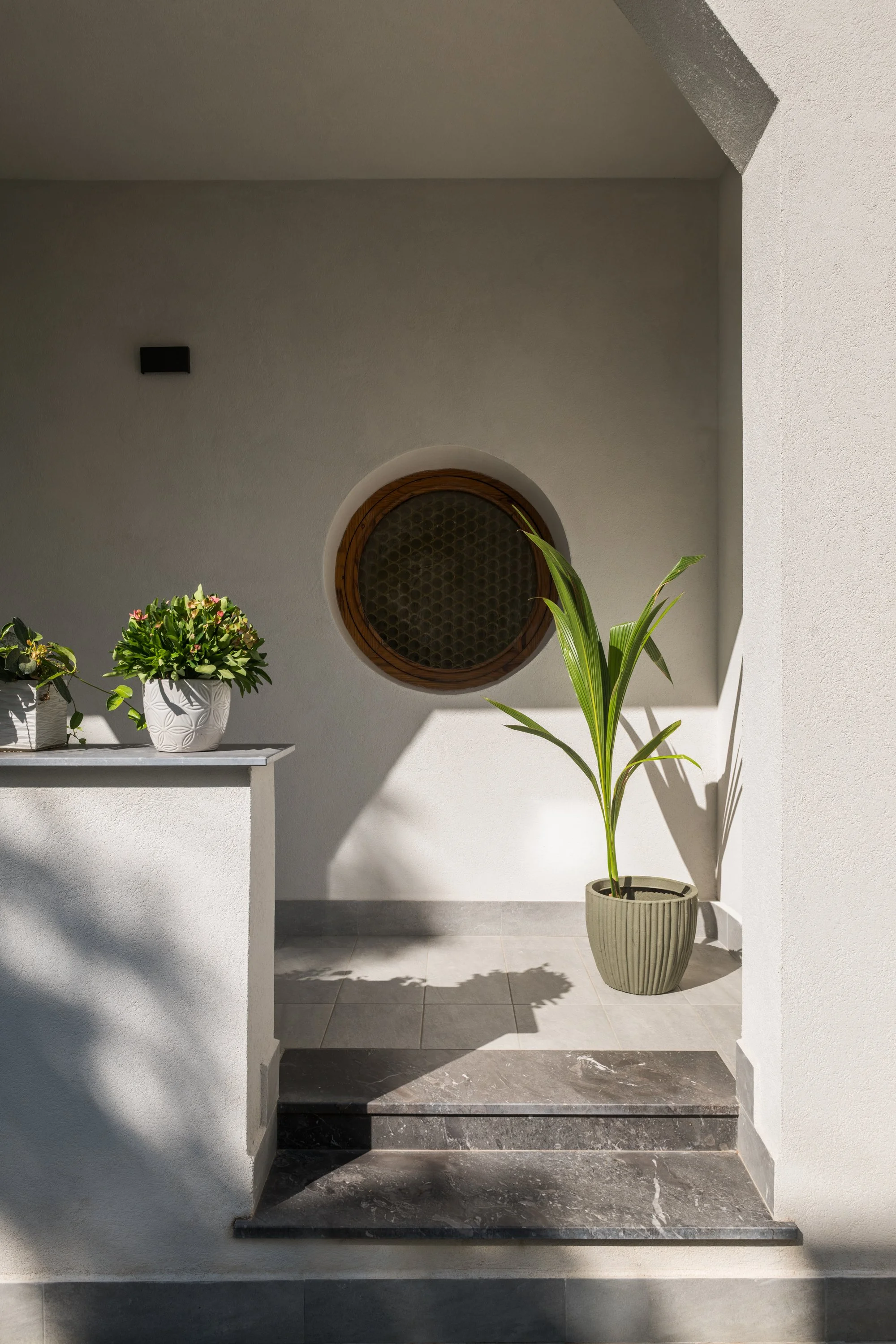 Dettaglio architettonico del portico della villa unifamiliare di circa 340 m² trasformata in due abitazioni autonome a Mondello, Palermo. L’immagine mostra uno degli oblò circolari originali della villa edificata negli anni Cinquanta, con telaio in l