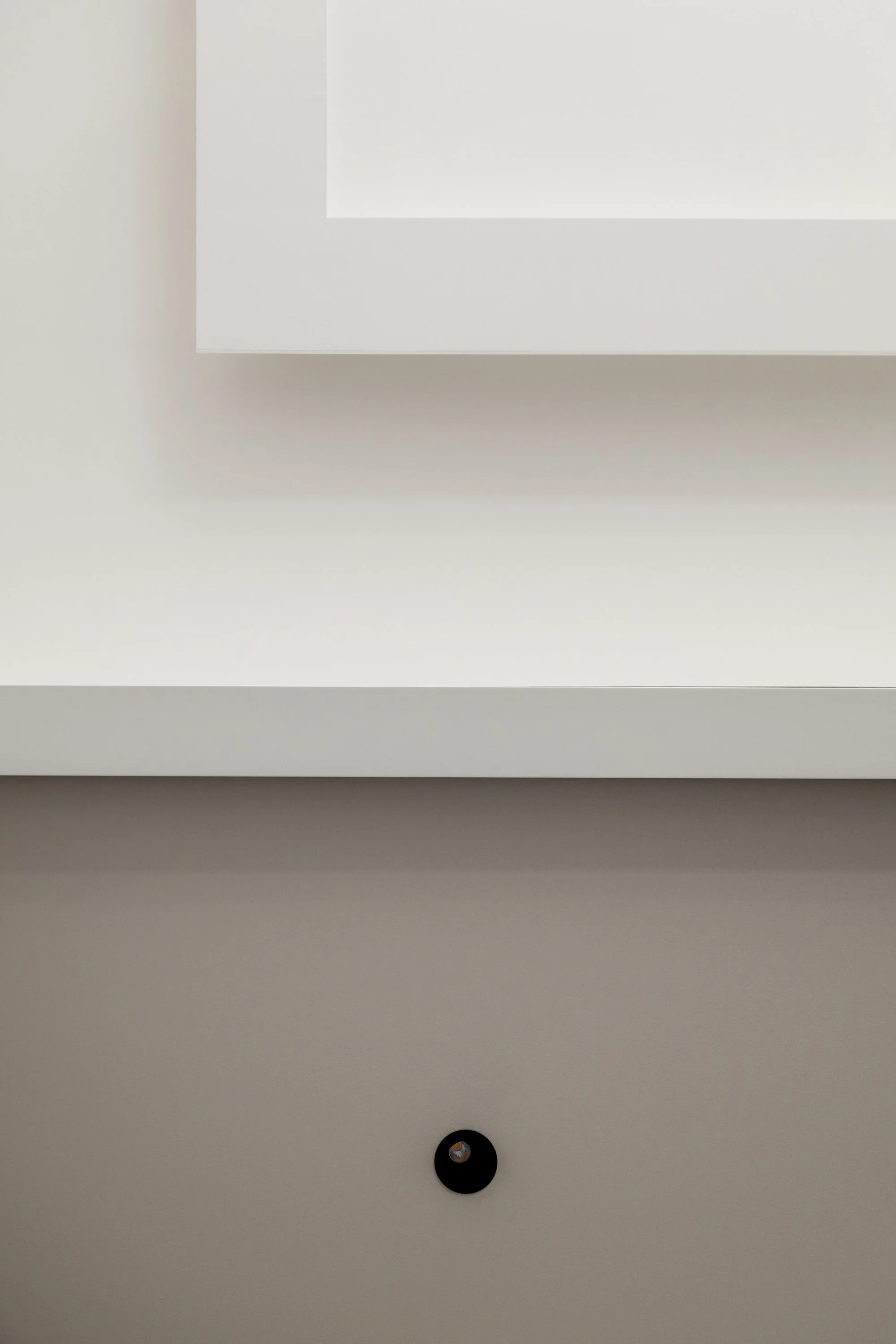 Dettaglio delle superfici bianche, delle nicchie su misura e dell’illuminazione a contrasto che caratterizzano il progetto Ink. La composizione valorizza il rapporto tra luce, materia e geometria all’interno dell’appartamento ristrutturato a Palermo.