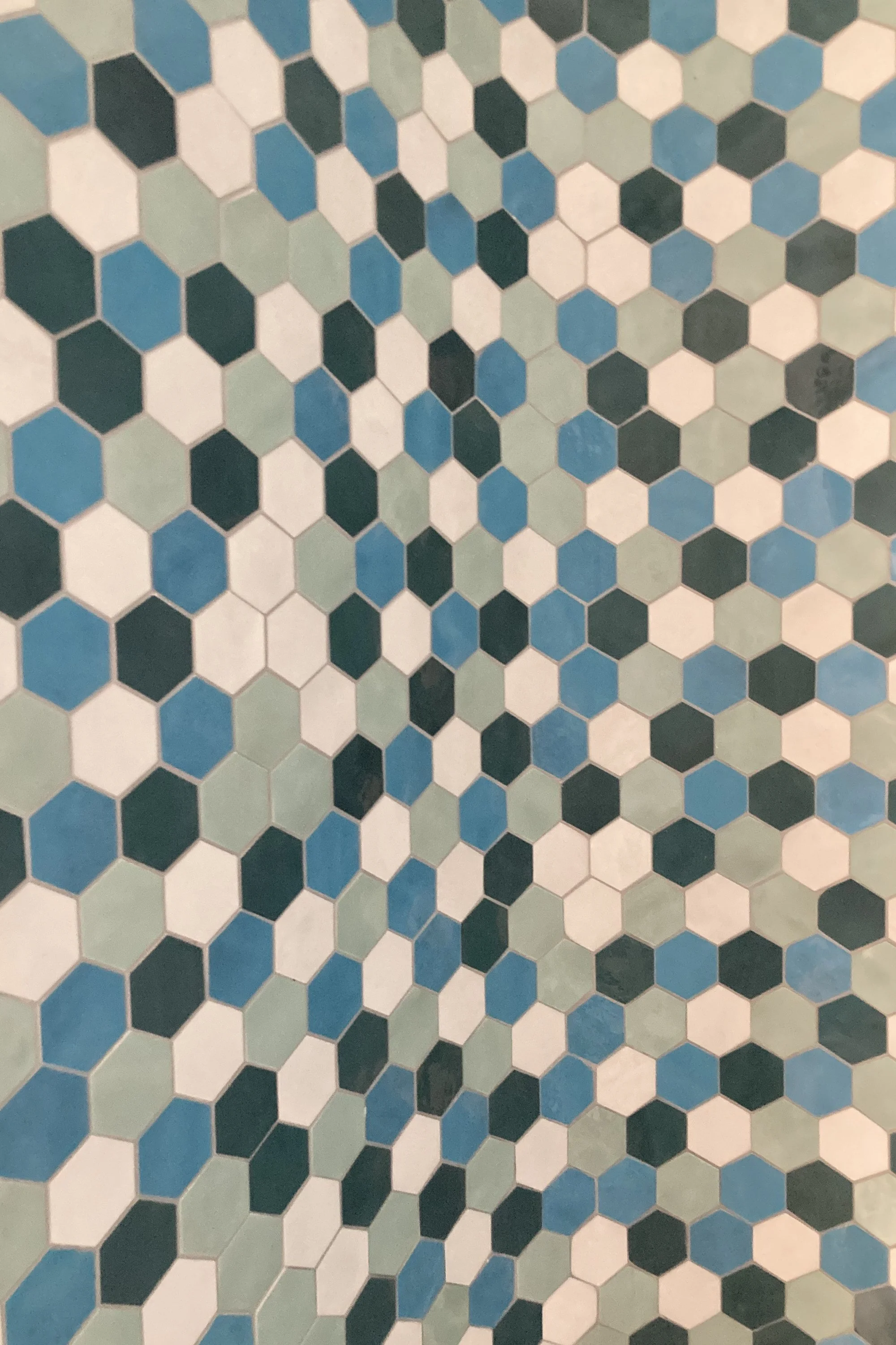 Dettaglio del rivestimento ceramico utilizzato nei bagni del progetto Lithos. Le tonalità del blu, dell’azzurro e del verde richiamano il mare di Pantelleria e introducono una componente cromatica che dialoga con il bianco delle superfici curve e con