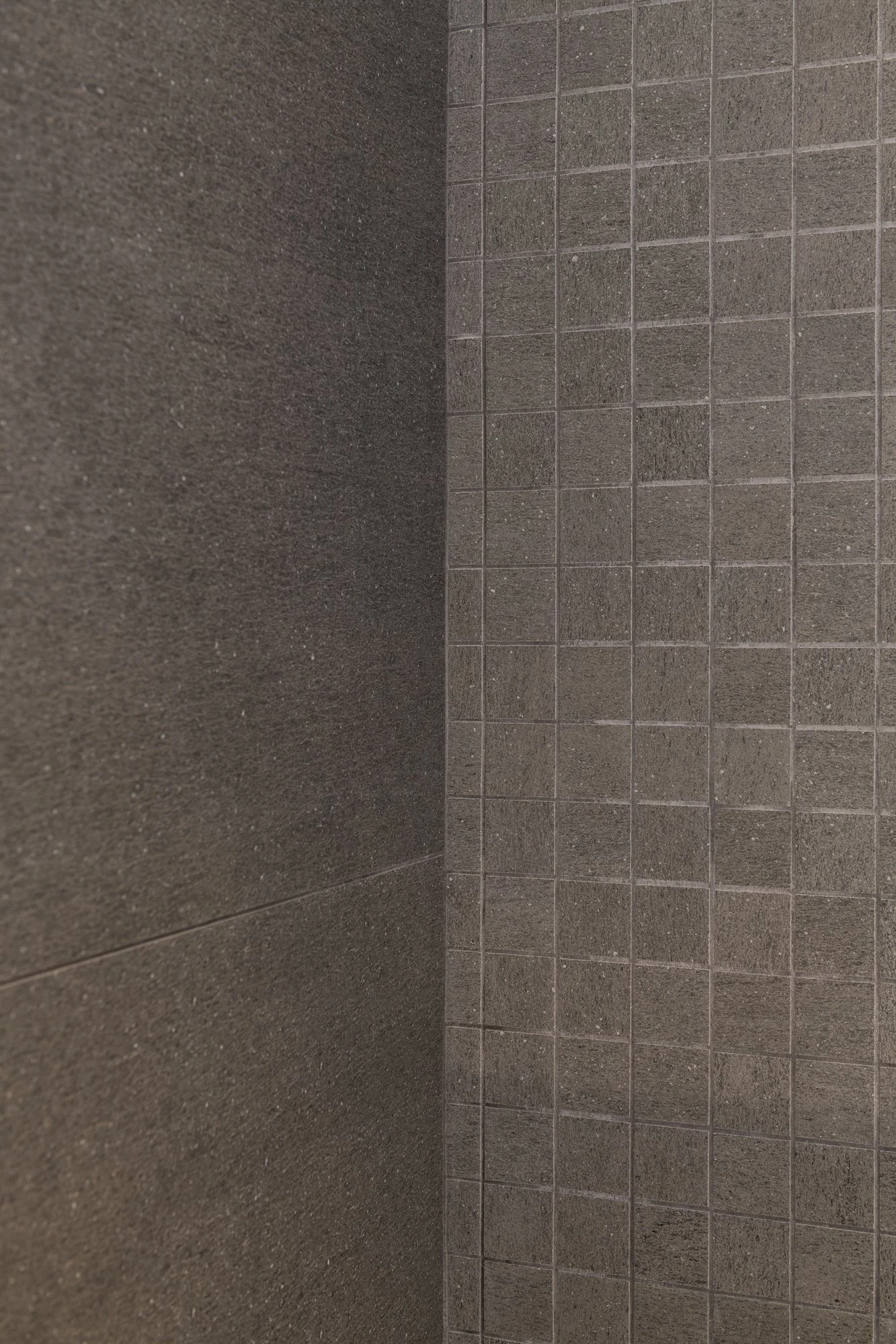 Dettaglio di rivestimenti in gres effetto pietra e mosaico coordinato nel bagno del progetto Mikado.