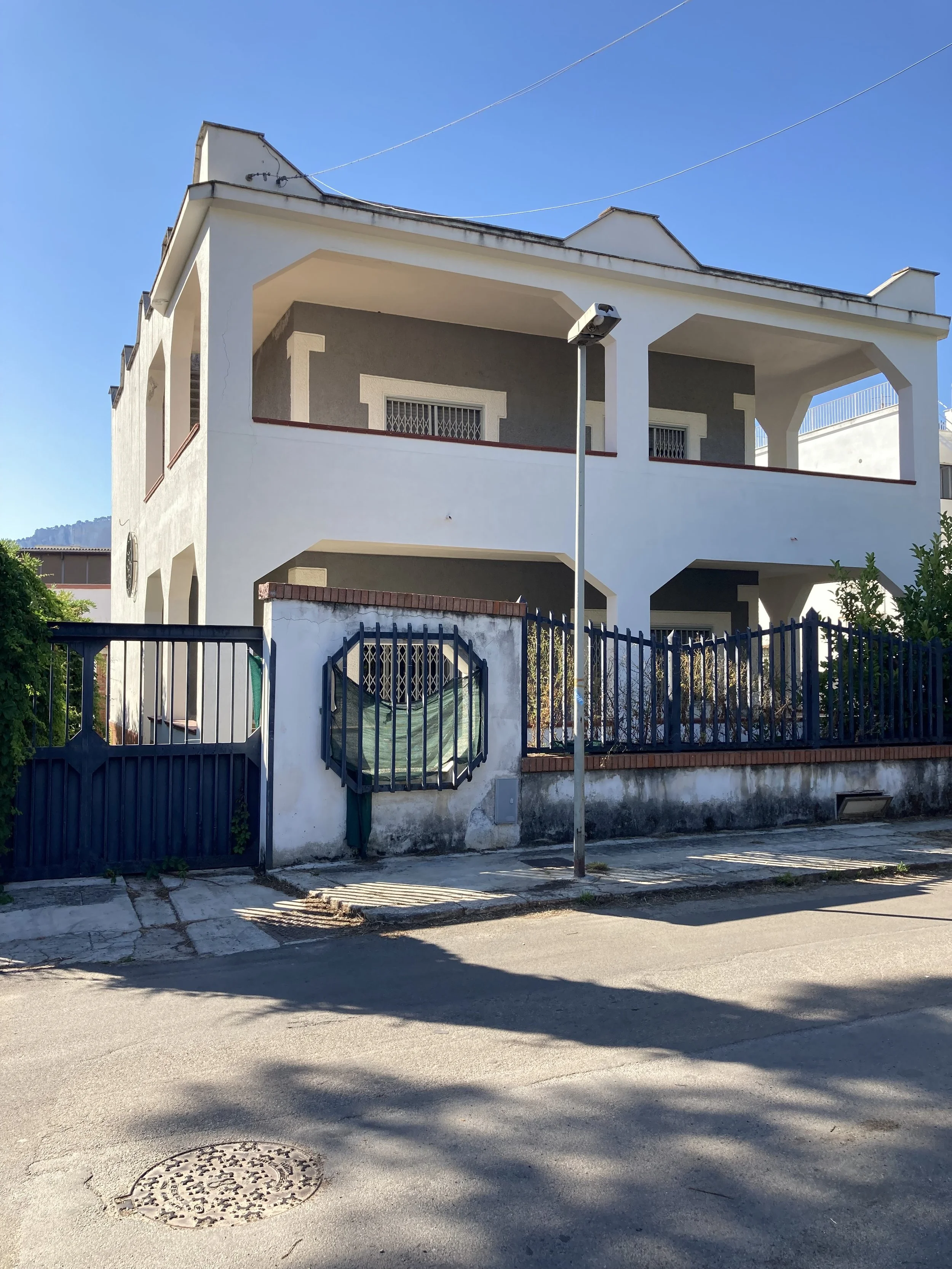 Vista del prospetto principale della villa a Mondello nello stato di fatto prima dell'intervento di ristrutturazione. Il progetto di Francesco Di Raimondo trasforma un'abitazione unifamiliare di circa 340 m² in due unità indipendenti attraverso un nu