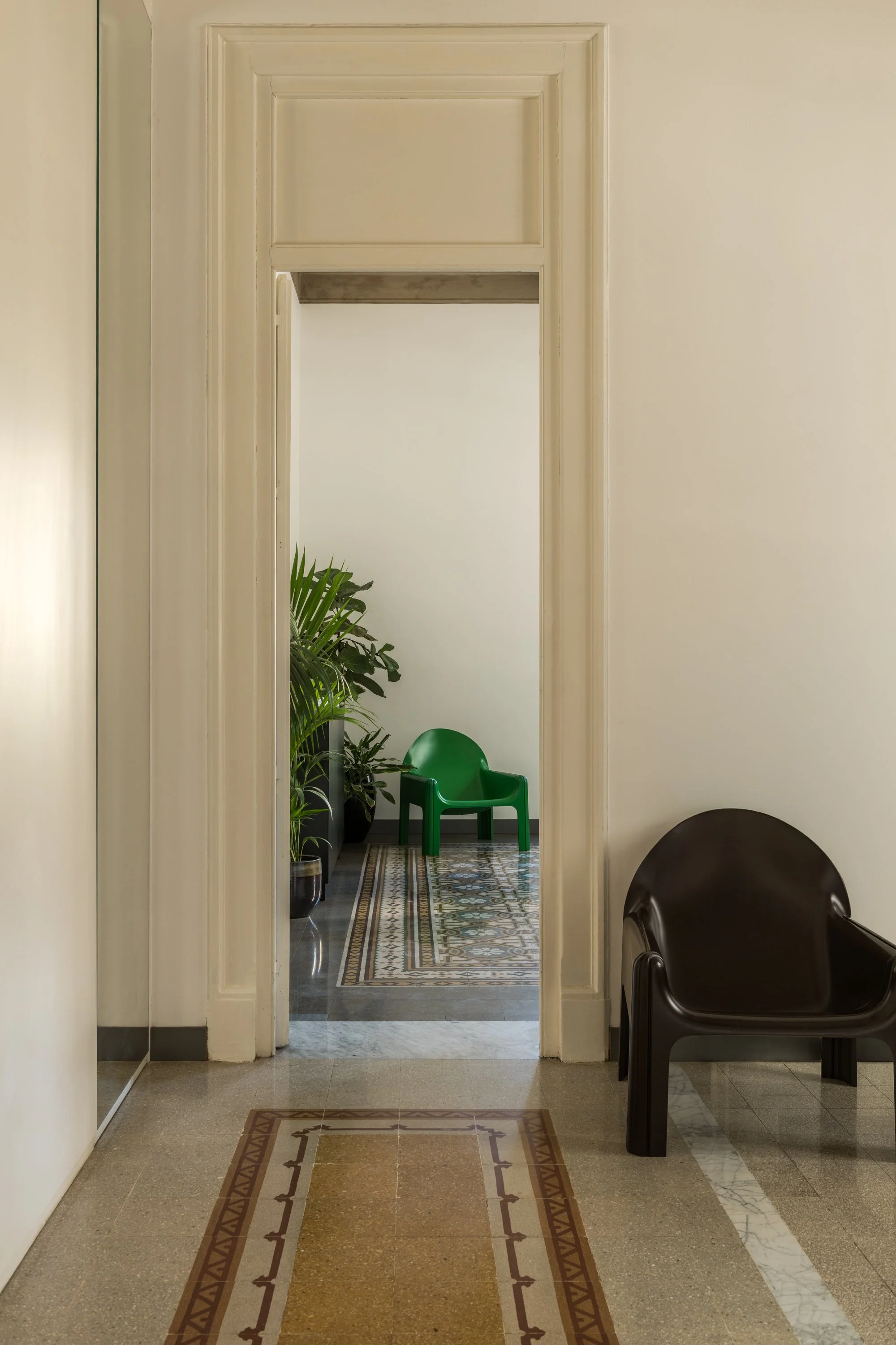 Interno di un appartamento storico ristrutturato a Palermo da FDR Architetto di Francesco Di Raimondo, con porta storica restaurata, pavimento in cementine ricomposte, soglia in marmo e arredi di design contemporaneo.