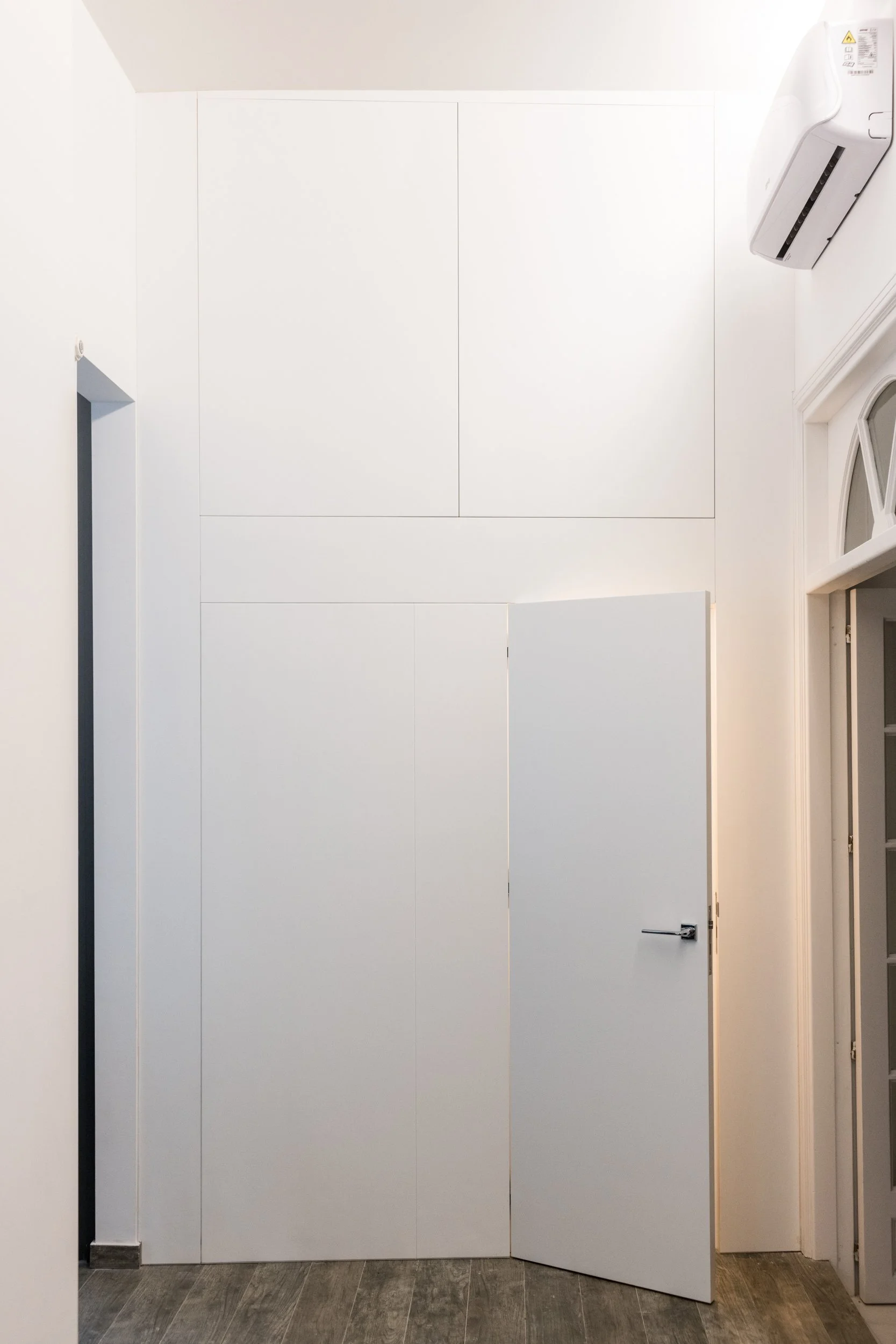 Armadiatura a tutta altezza con porta filo muro integrata in appartamento ristrutturato a Palermo. L'armadiatura su misura realizzata nel progetto Dinamo, intervento di ristrutturazione e risanamento di un appartamento a Palermo. La falegnameria a tu