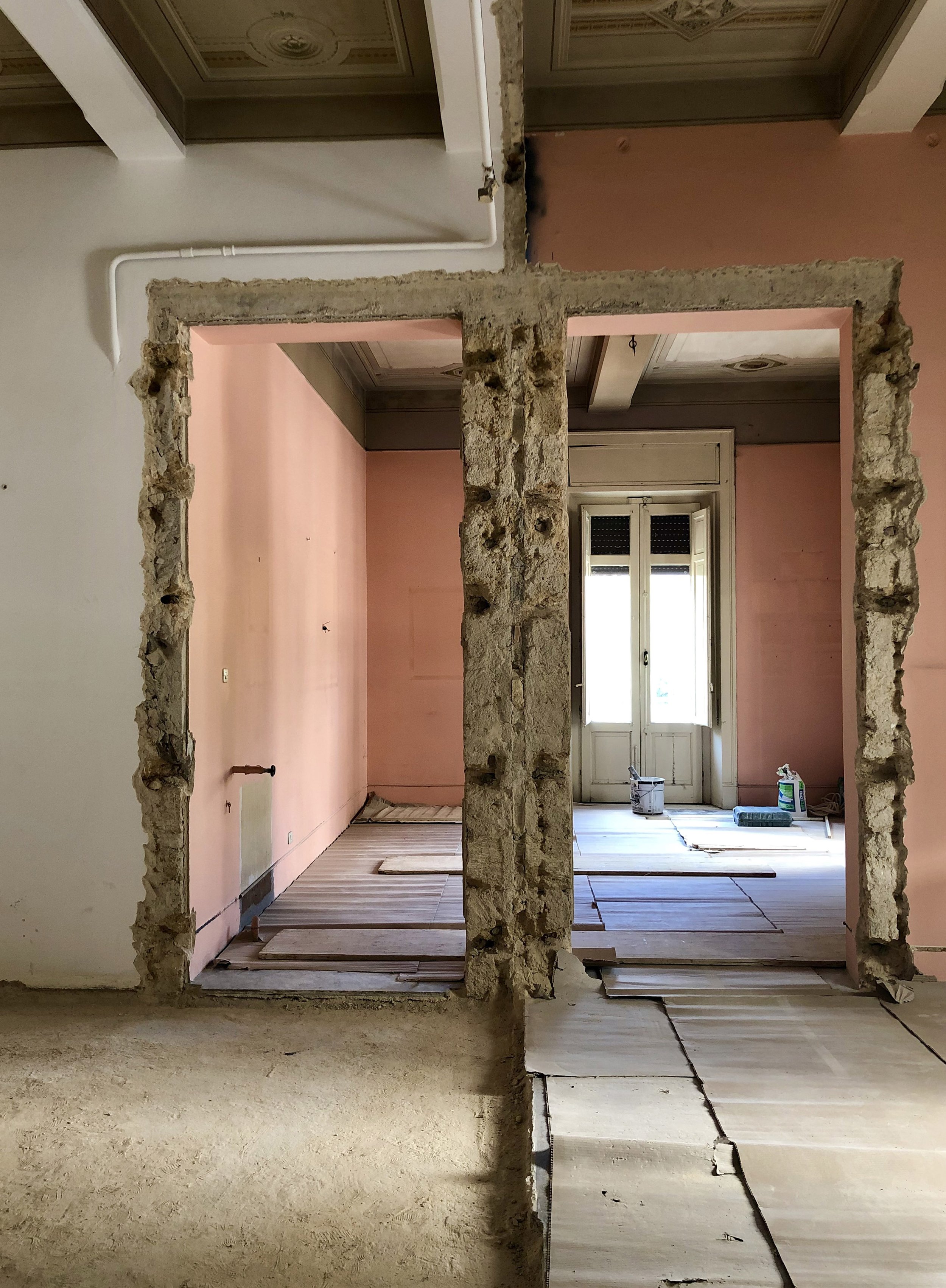 Direzione lavori e fase di cantiere per la trasformazione di un appartamento storico a Palermo. L’immagine documenta la demolizione controllata delle murature e la formazione delle nuove aperture che ridefiniscono l’ingresso dell’abitazione e le rela