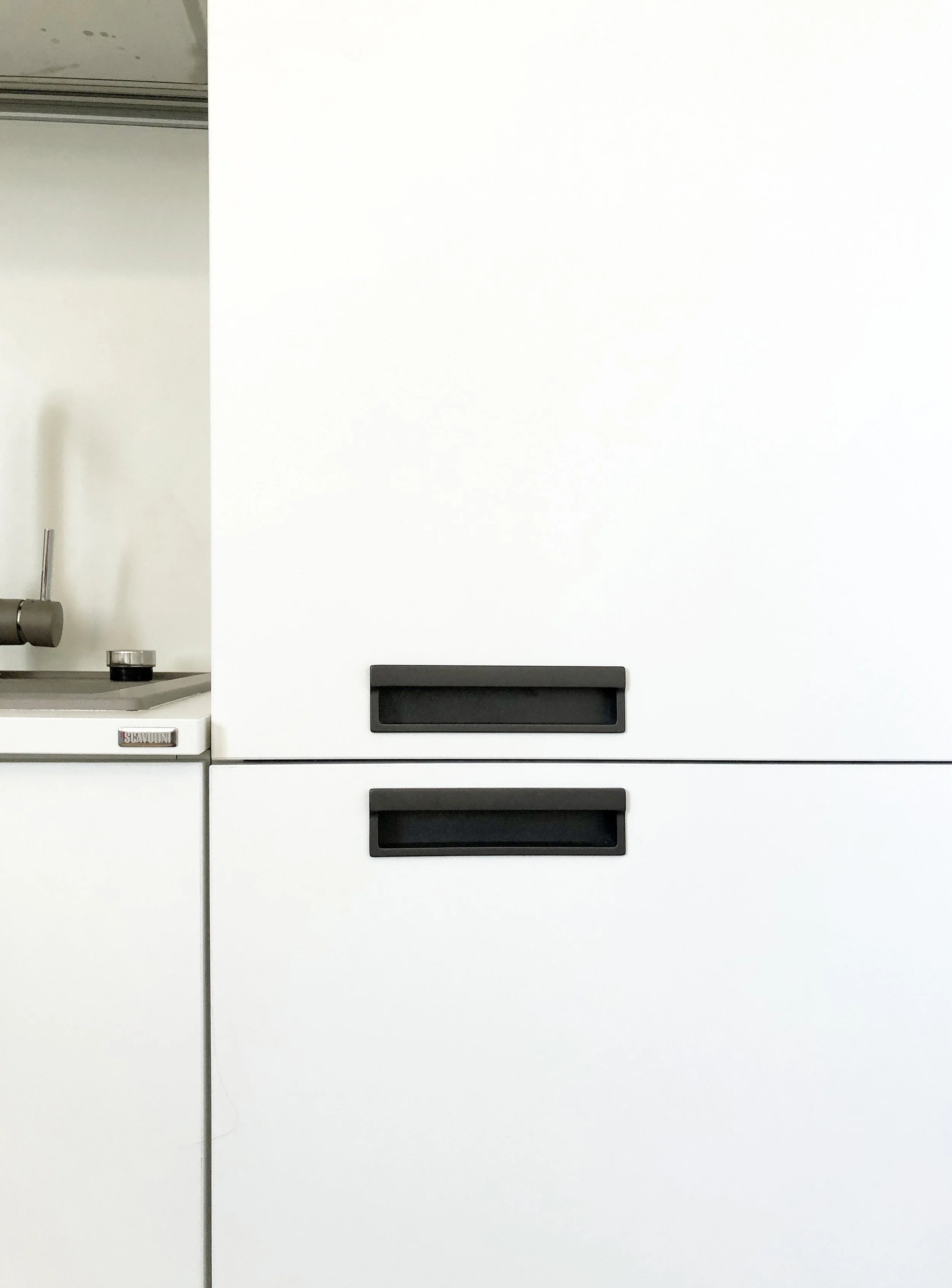 Particolare della cucina contemporanea realizzata all'interno di un appartamento storico restaurato a Palermo. Il progetto integra arredi su misura, finiture minimali e materiali contemporanei con pavimenti storici, soffitti decorati e elementi origi
