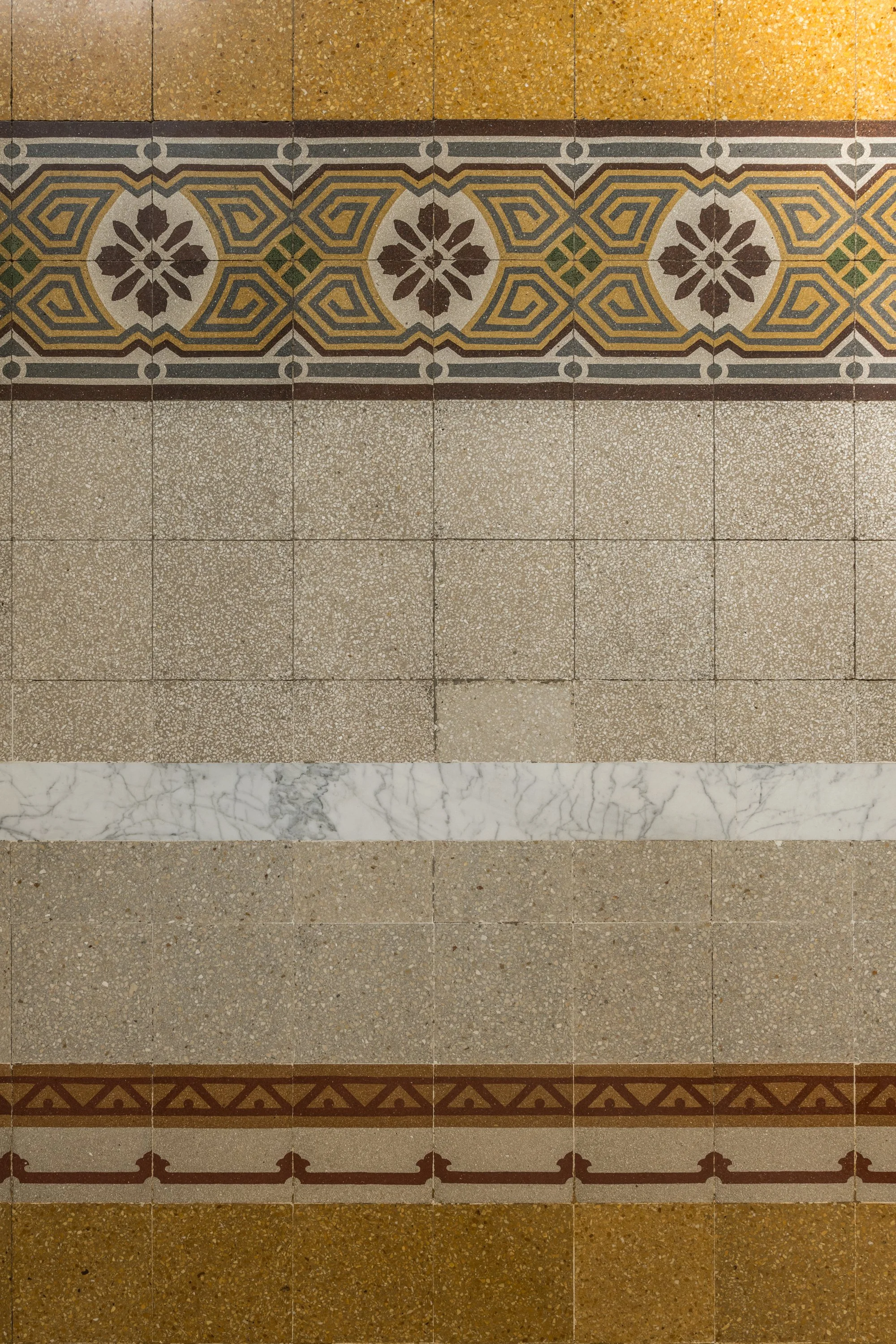 Dettaglio del pavimento in cementine storiche ricomposte nell’appartamento Unquarto a Palermo, con decorazioni geometriche e floreali e soglie in marmo che conservano le tracce della configurazione originaria.