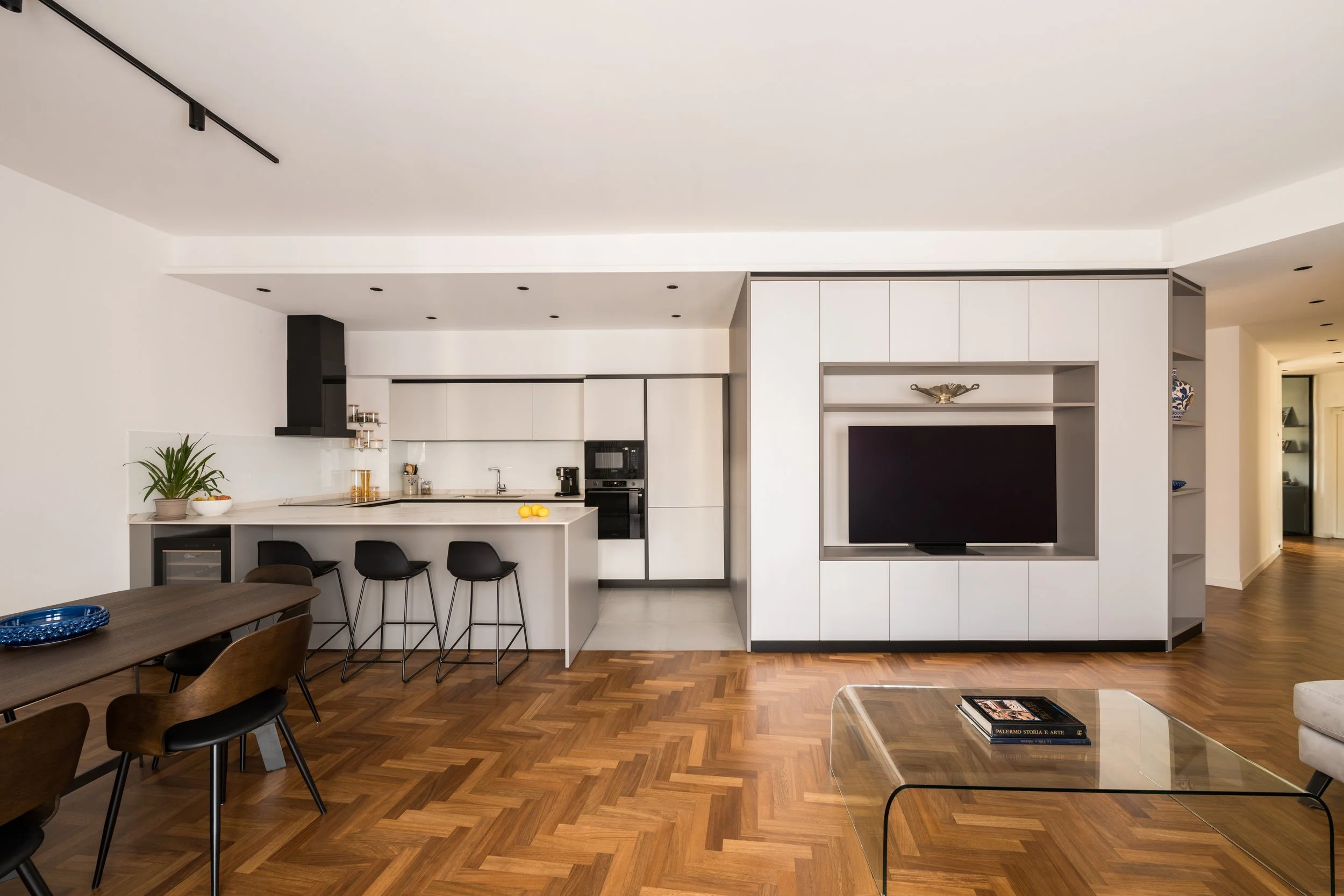 Vista generale dell'appartamento ZingZak a Palermo con cucina Elmar a isola, volume centrale attrezzato, soggiorno open space e parquet in iroko a spina italiana.