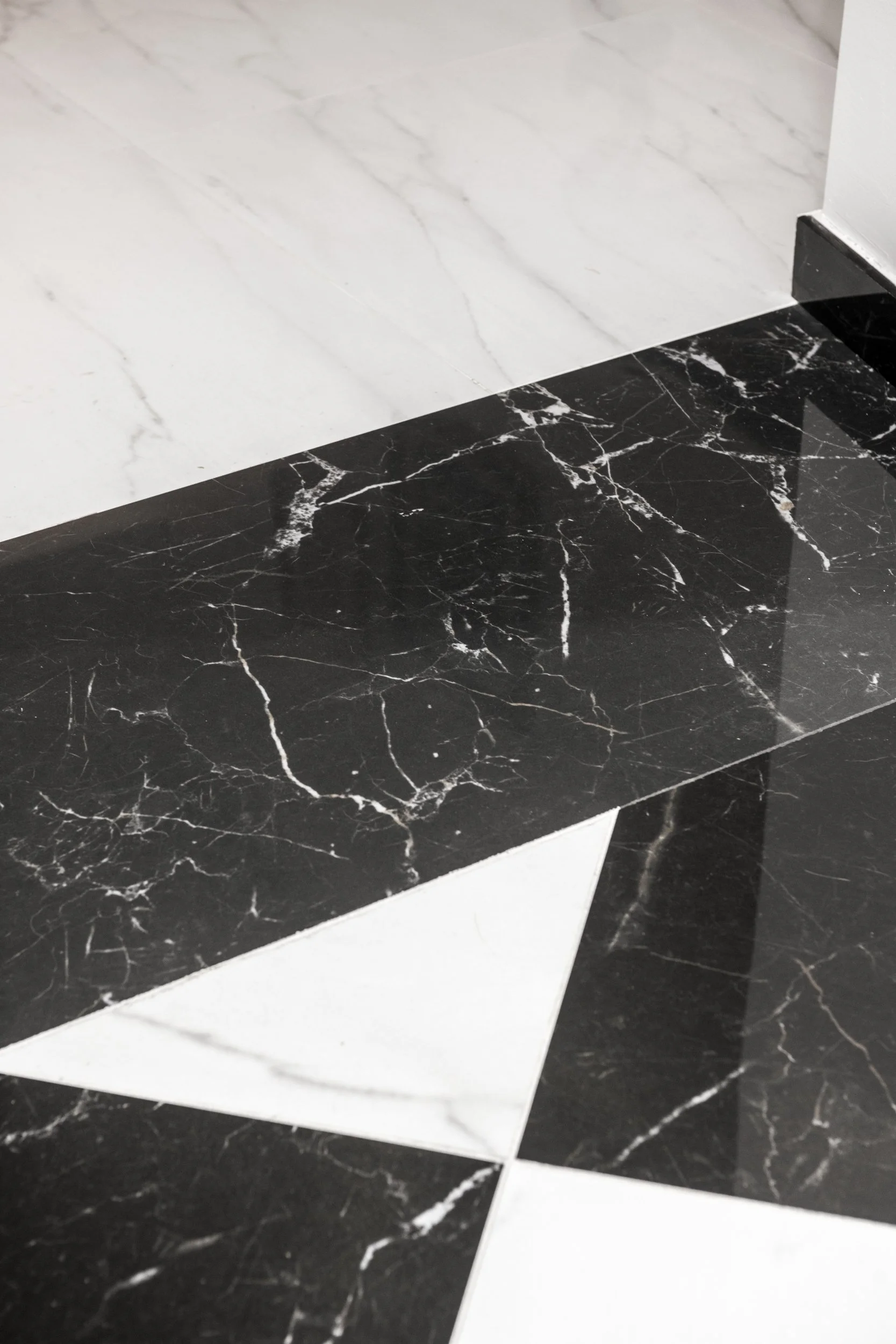 Dettaglio della pavimentazione in gres porcellanato effetto marmo bianco e nero nell'ingresso di un appartamento ristrutturato a Palermo. Pavimento in gres porcellanato effetto marmo bianco e nero realizzato nell'ambito della ristrutturazione di un a