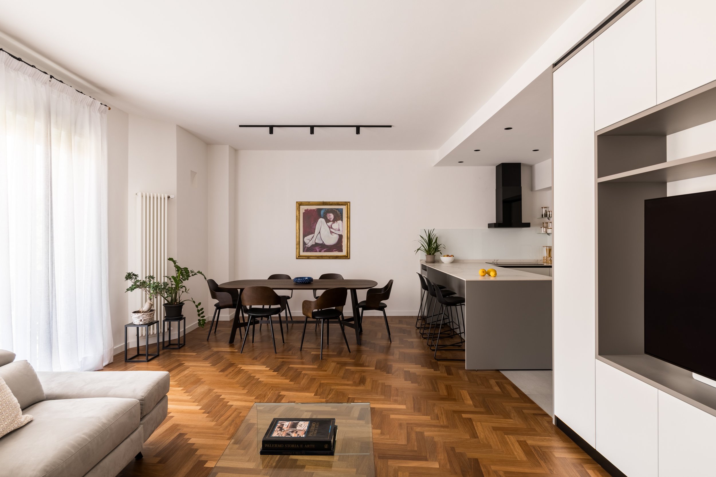 Ristrutturazione di FDR architetto dell'appartamento contemporaneo a Palermo con ridisegno degli spazi interni, cucina con isola, arredi su misura e parquet a spina. Il progetto organizza la casa attraverso volumi architettonici, continuità materica 