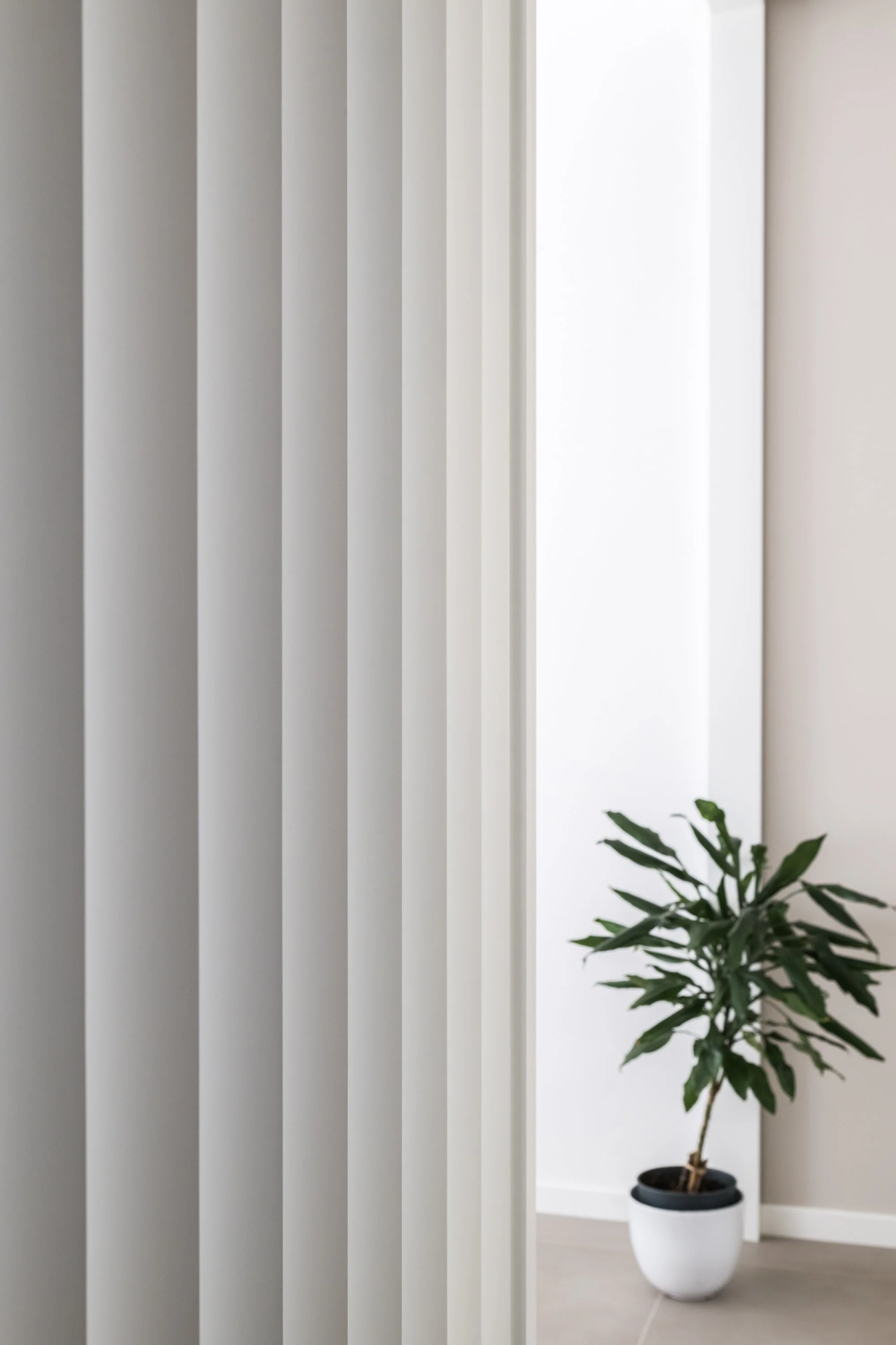 Dettaglio del brise-soleil laccato bianco che filtra la luce e mantiene in relazione i diversi ambienti dell’appartamento Ink. L’elemento segna il passaggio tra corridoio e zona giorno senza interrompere la continuità dello spazio.