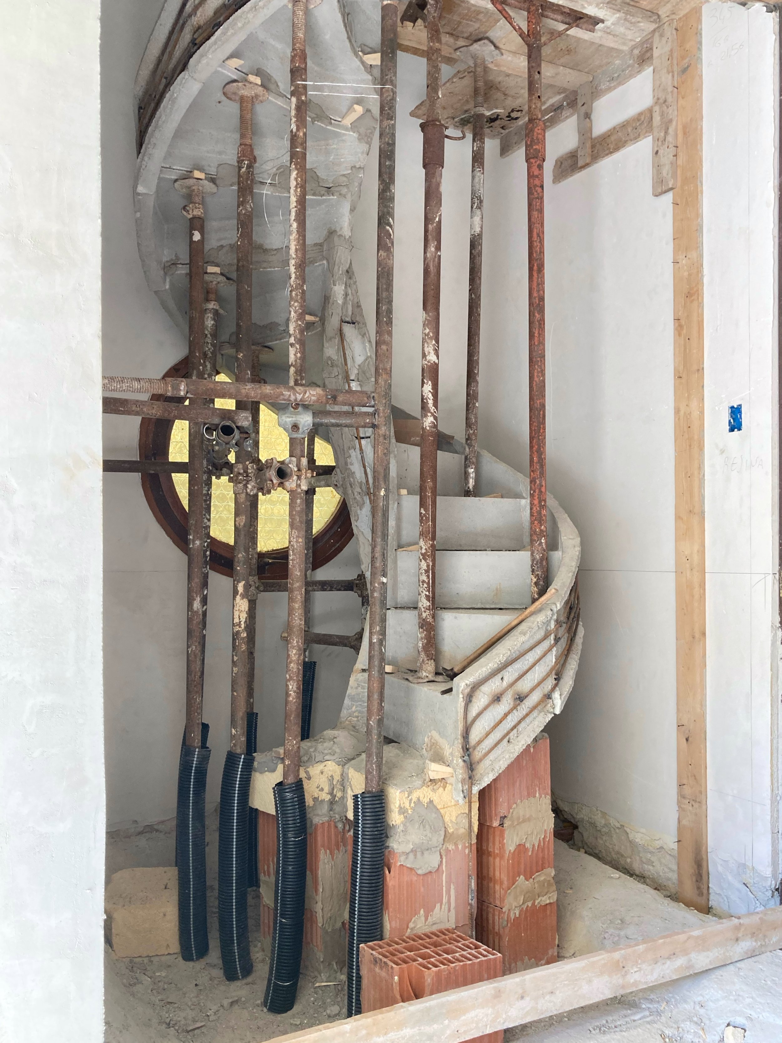 Realizzazione della scala elicoidale. Scala elicoidale durante le fasi di puntellamento e consolidamento nel cantiere di trasformazione della villa. Fase di cantiere durante la realizzazione della scala elicoidale prefabbricata. Il puntellamento temp
