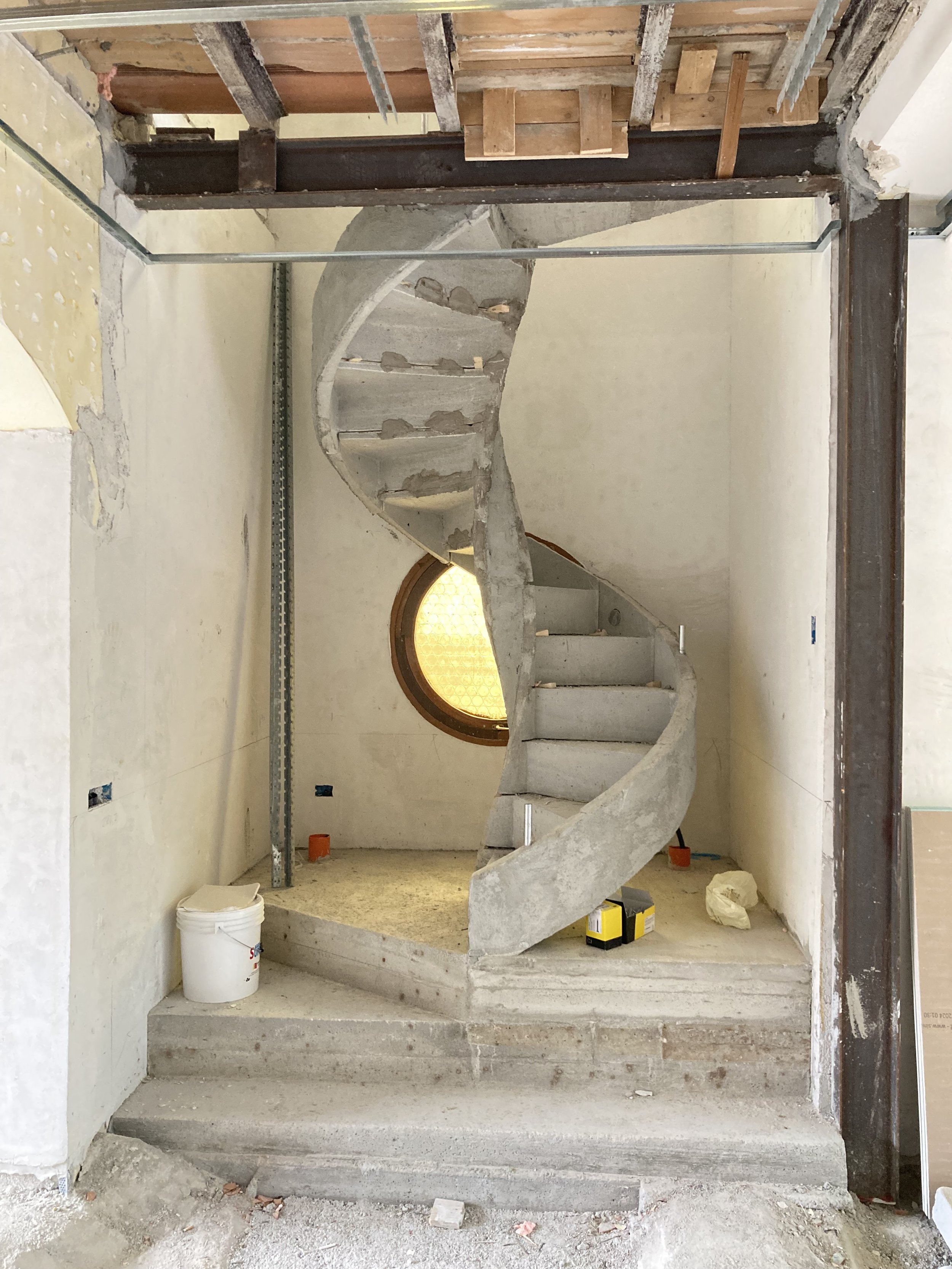 Installazione della scala elicoidale prefabbricata durante la trasformazione di una villa unifamiliare in due abitazioni indipendenti.