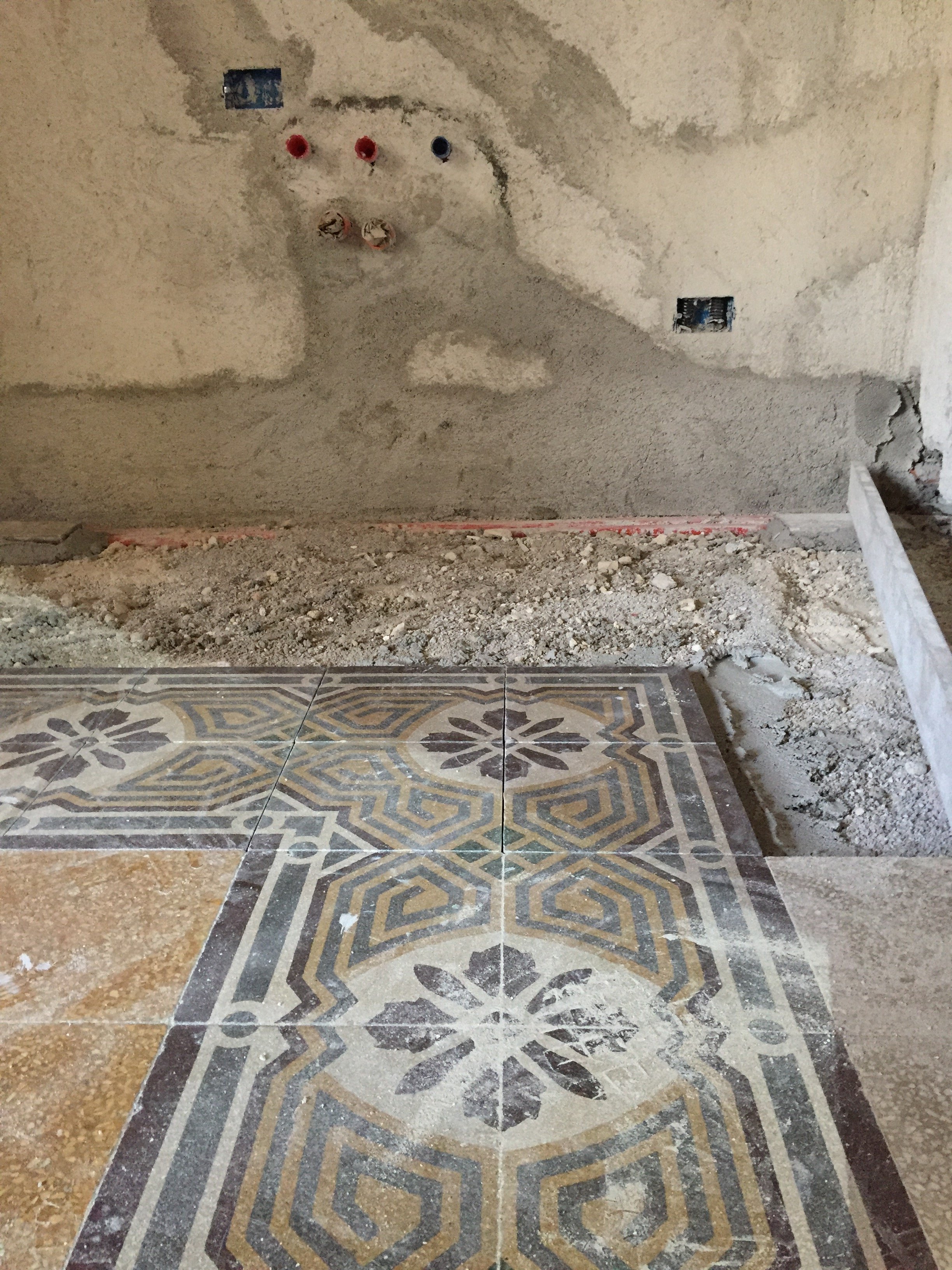 Restauro e recupero di pavimenti storici in cementine durante la ristrutturazione di un appartamento d'epoca a Palermo. L'immagine documenta la fase di cantiere nella quale il tappeto di cementine originali viene smontato per consentire l'inserimento