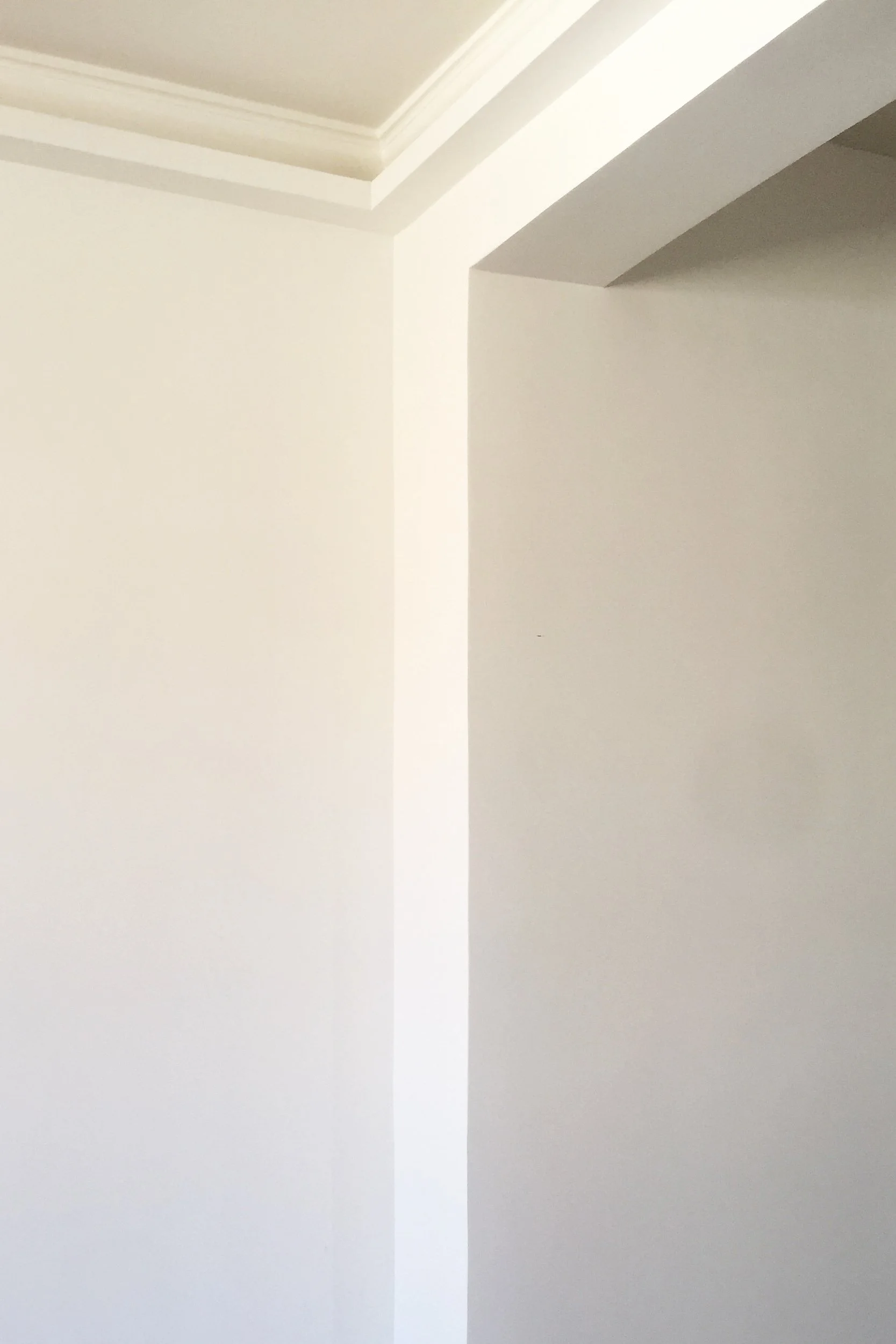 Dettaglio architettonico dell'appartamento Verticalismi a Palermo. Volumi bianchi, cornici esistenti e luce indiretta definiscono una composizione essenziale basata sul dialogo tra pieni, vuoti e geometrie.