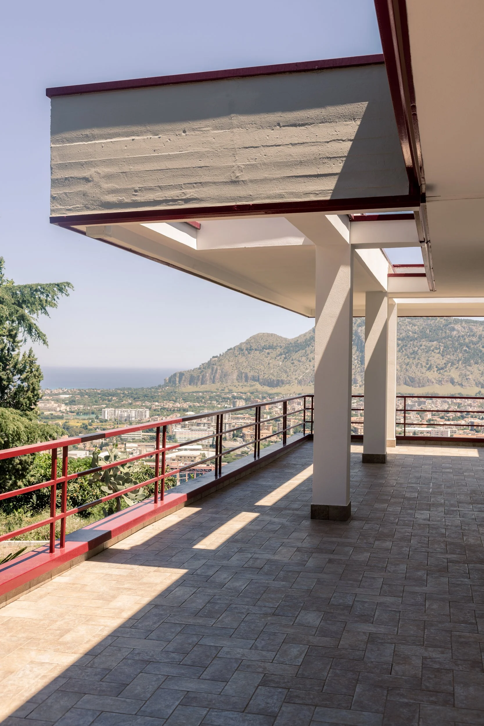Portico della villa con struttura geometrica e vista panoramica sul territorio di Palermo.