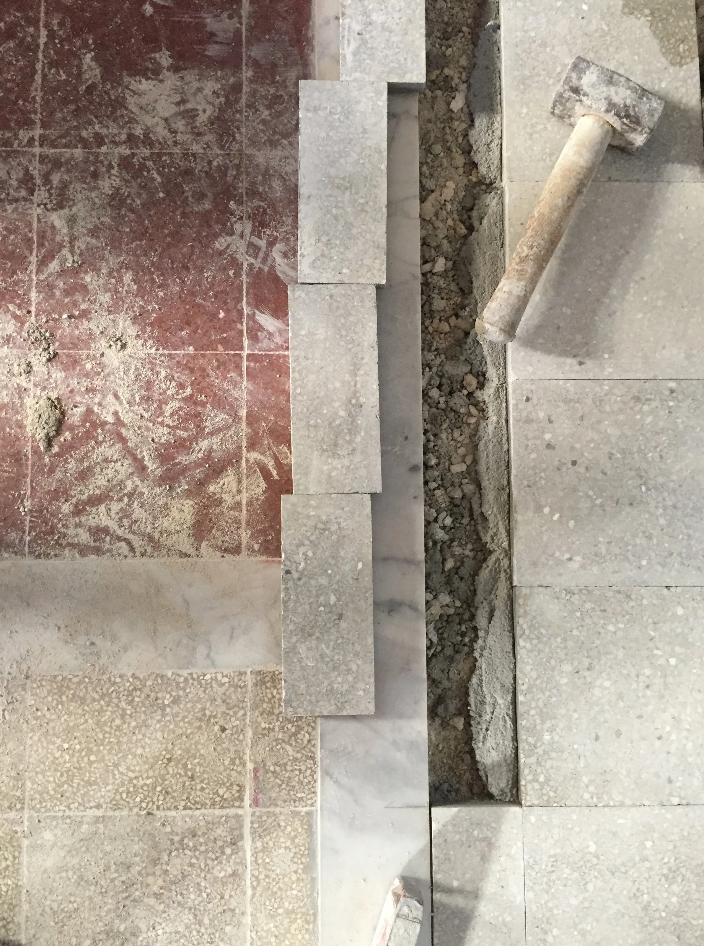 Realizzazione di una soglia in marmo durante il restauro e la riqualificazione di un appartamento d'epoca a Palermo. L'intervento accompagna la trasformazione della distribuzione interna e rende leggibili le tracce delle precedenti partizioni demolit