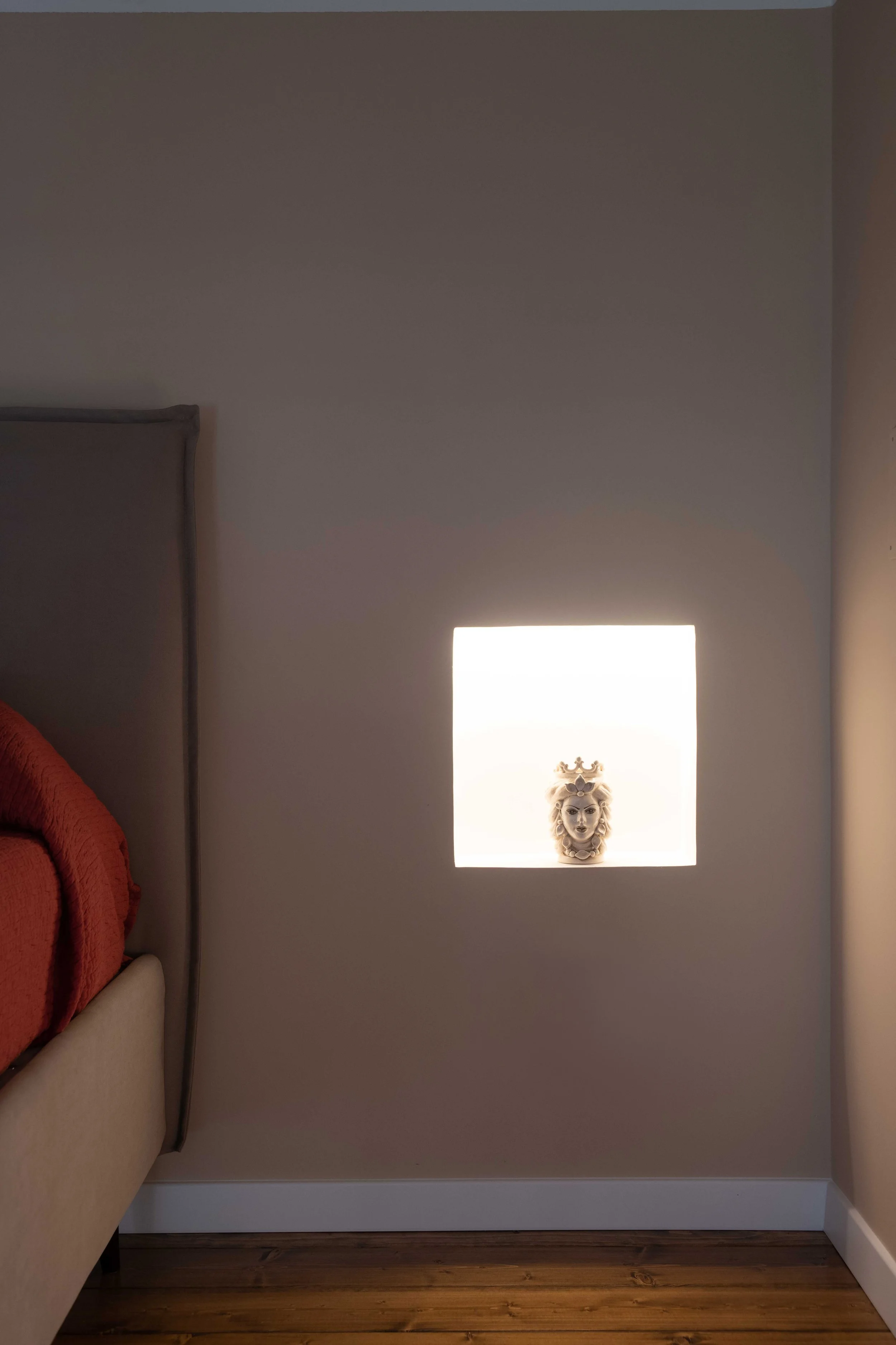 Nel progetto Bi-Cubo la luce assume un ruolo fondamentale nella costruzione della percezione spaziale. In questa immagine la nicchia led accesa incassata nella parete diventa un dispositivo architettonico capace di misurare lo spessore del volume e d