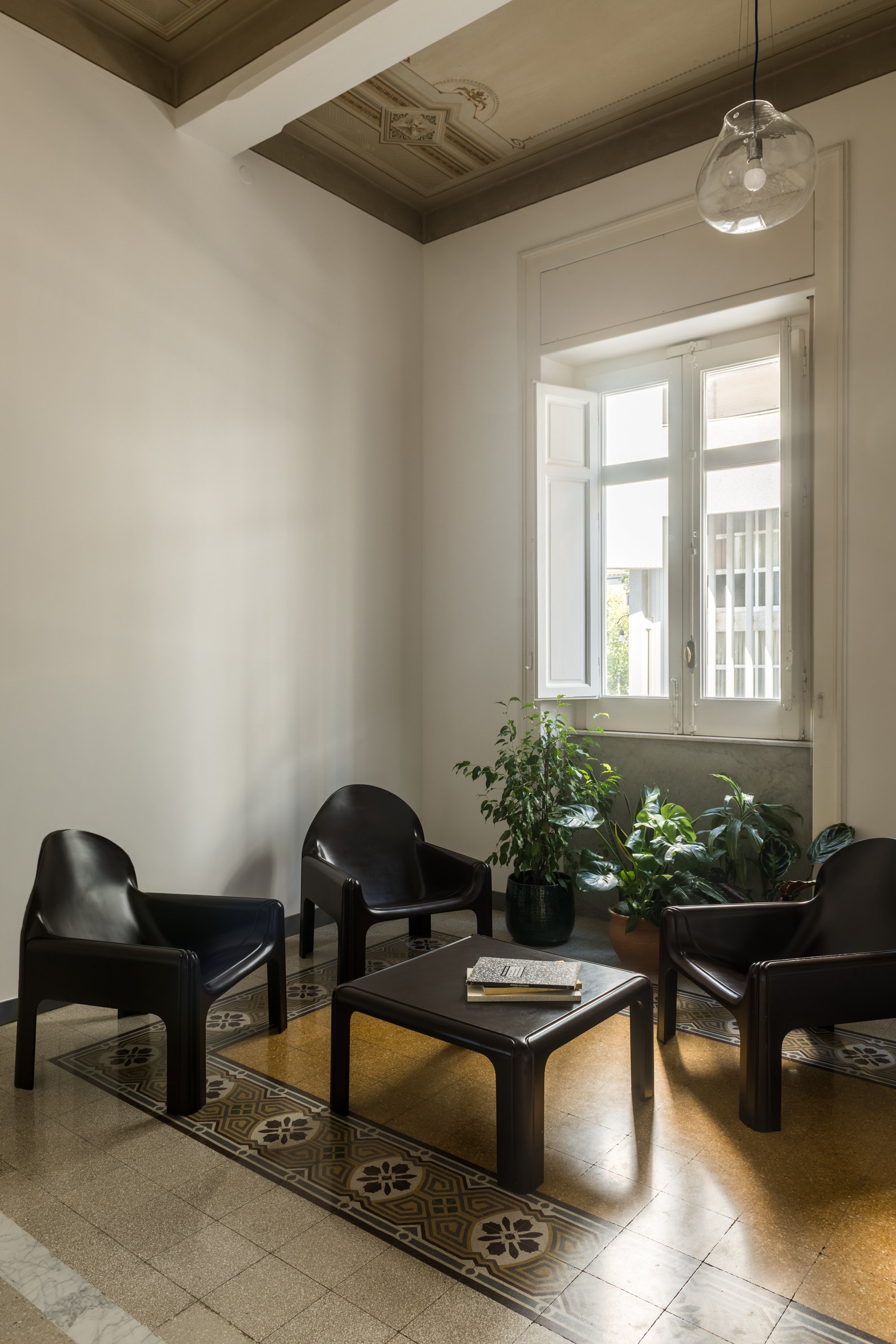 Salotto con arredi di design Kartell in un appartamento storico ristrutturato a Palermo da Francesco Di Raimondo, con cementine storiche ricomposte, soffitto dipinto restaurato e infissi d’epoca integrati in un ambiente contemporaneo.