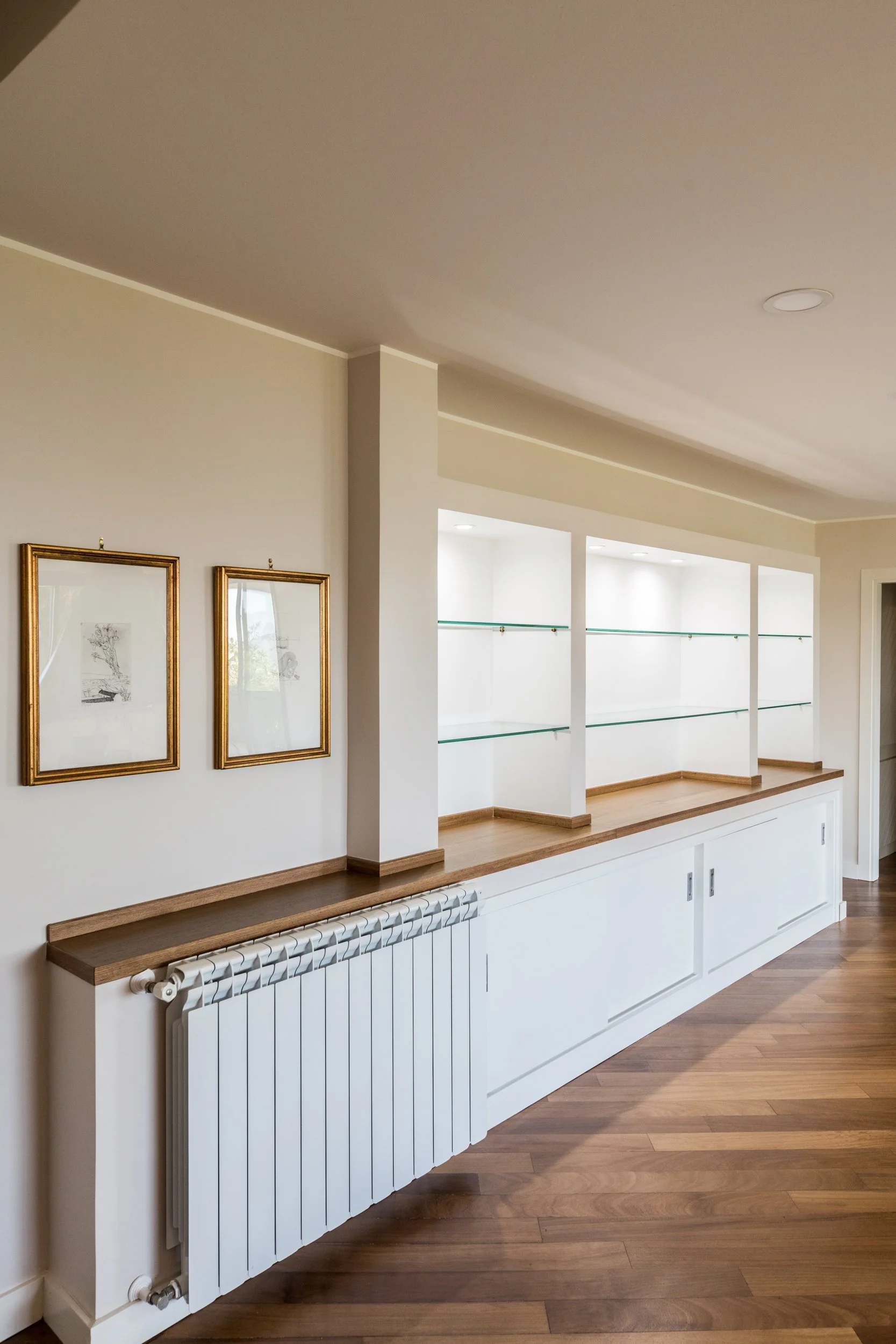 Parete attrezzata realizzata durante la ristrutturazione di una villa unifamiliare a Palermo. La parete attrezzata progettata da Francesco Di Raimondo Architetto integra contenimento ed esposizione in una composizione essenziale. L'elemento contribui