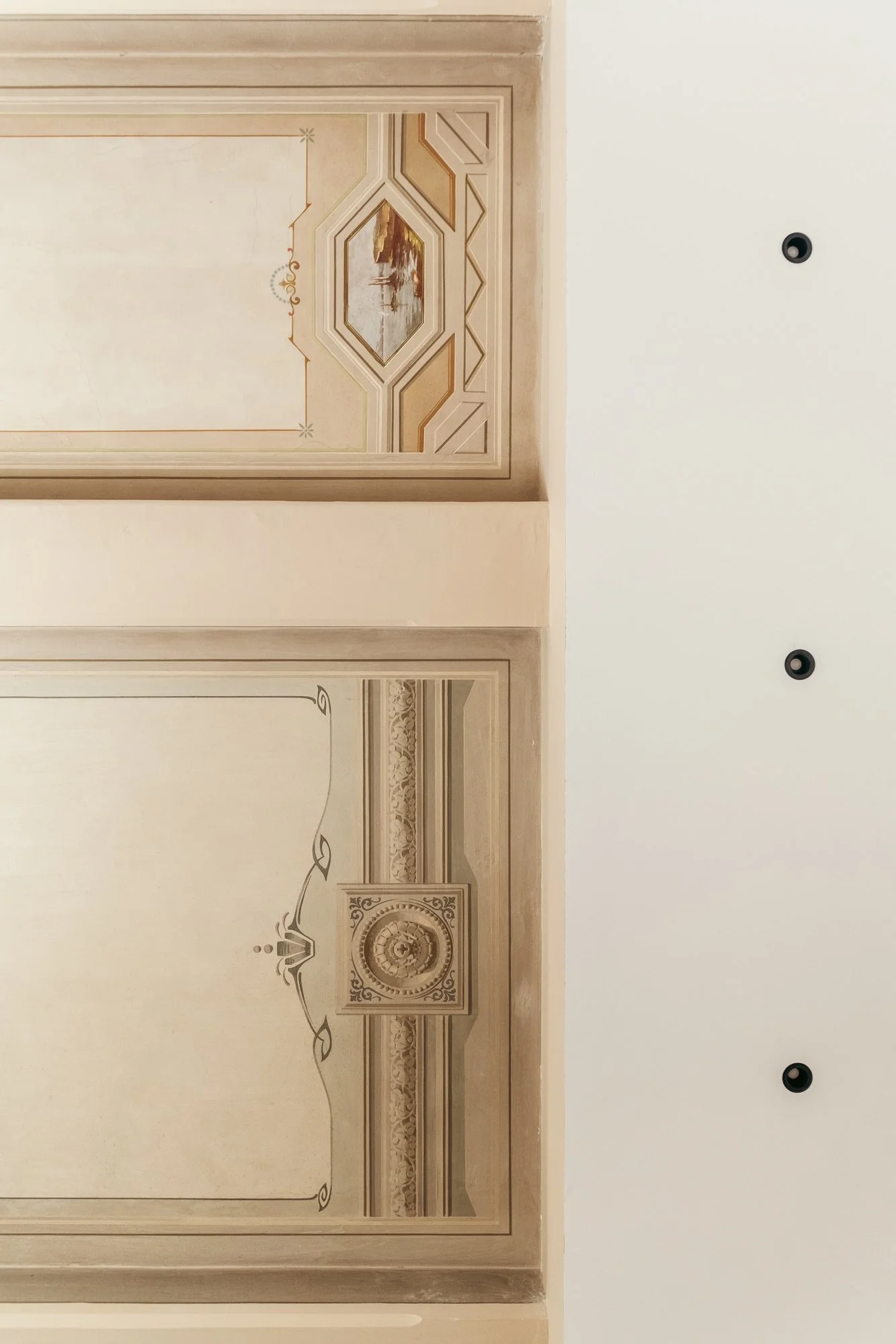 I soffitti decorati restaurati dell'appartamento a Palermo testimoniano il dialogo tra conservazione del patrimonio storico e intervento architettonico contemporaneo.