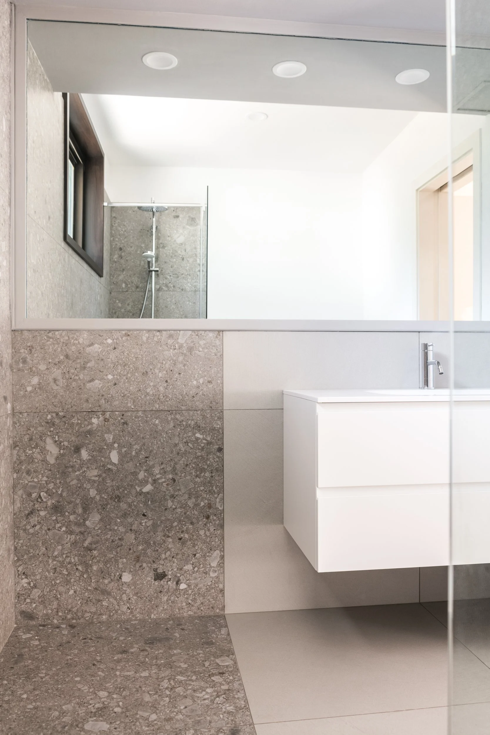Bagno contemporaneo con lavabo sospeso e rivestimenti in gres porcellanato in villa ristrutturata a Palermo. Il progetto di recupero della villa unifamiliare a Palermo introduce nuovi ambienti bagno caratterizzati da superfici continue, arredi sospes