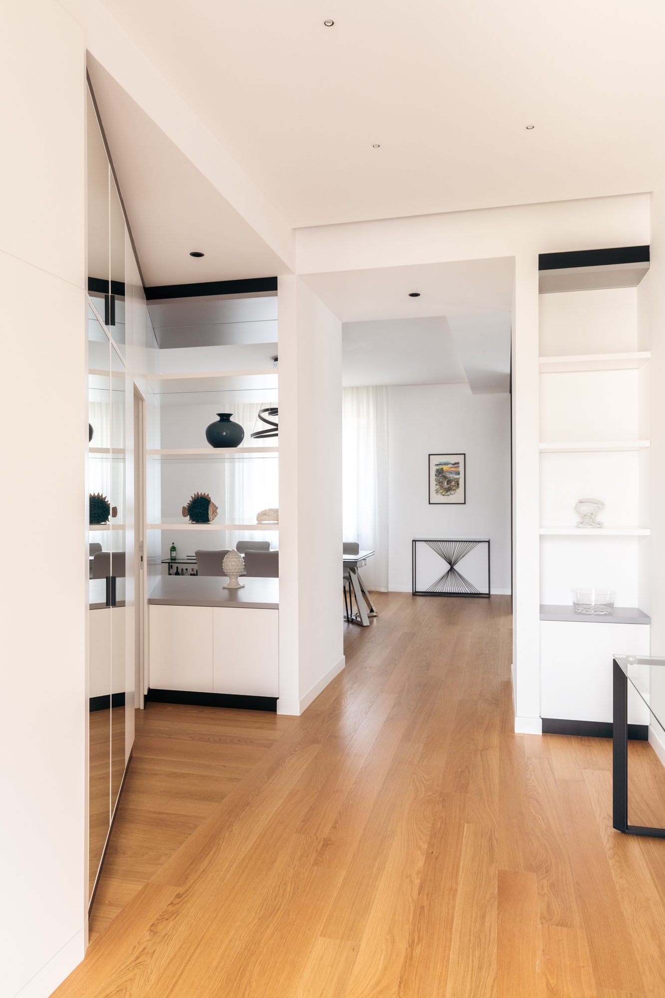 Le armadiature e le porte filo muro dell'appartamento a Palermo si integrano nella boiserie su misura, definendo uno spazio continuo caratterizzato da ordine, luce e profondità.