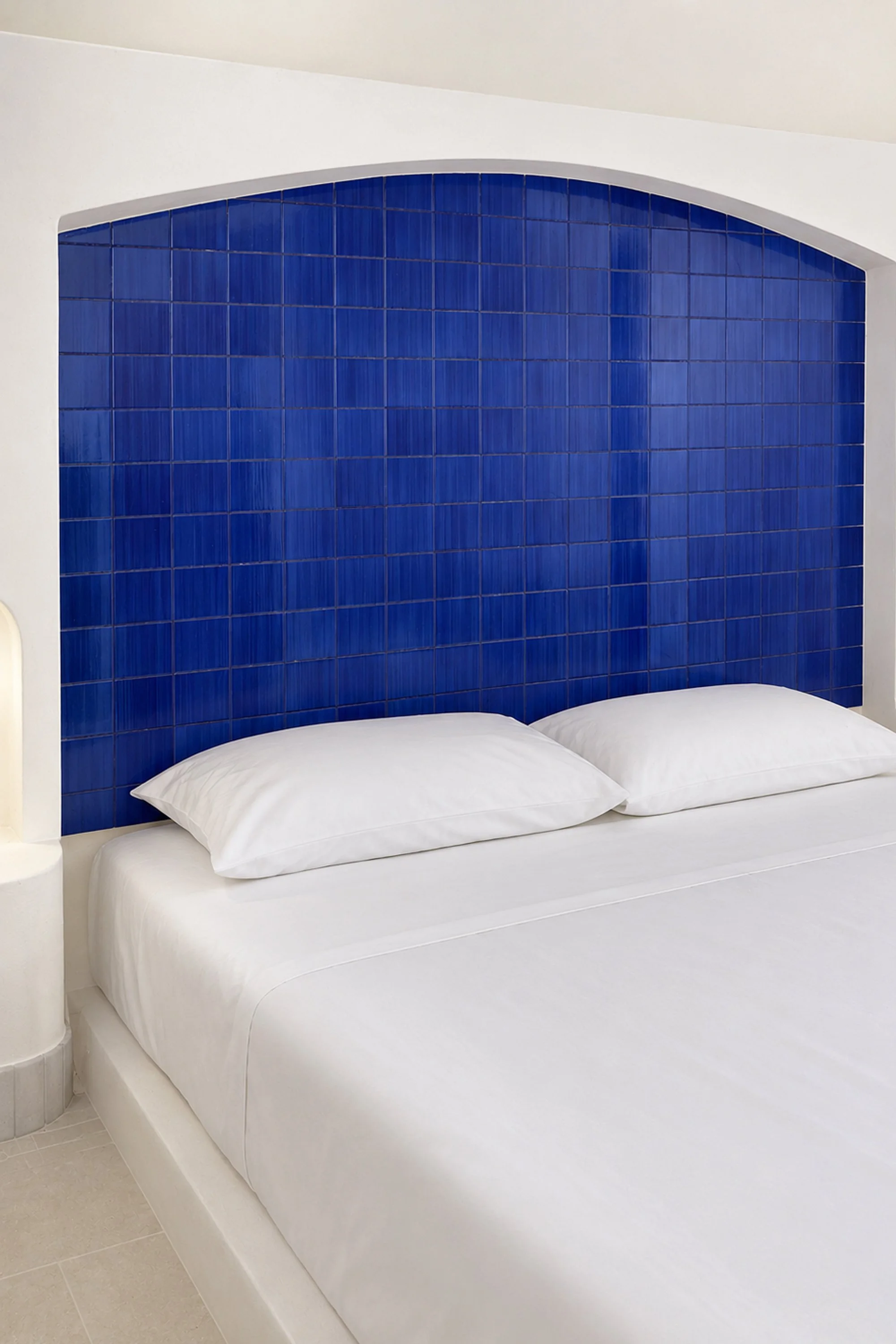 Dettaglio della camera da letto del progetto Lithos, recupero e ristrutturazione di un dammuso a Pantelleria di Francesco Di Raimondo architetto. Il letto in muratura emerge dalla massa costruita e si inserisce all’interno di una nicchia curva rivest