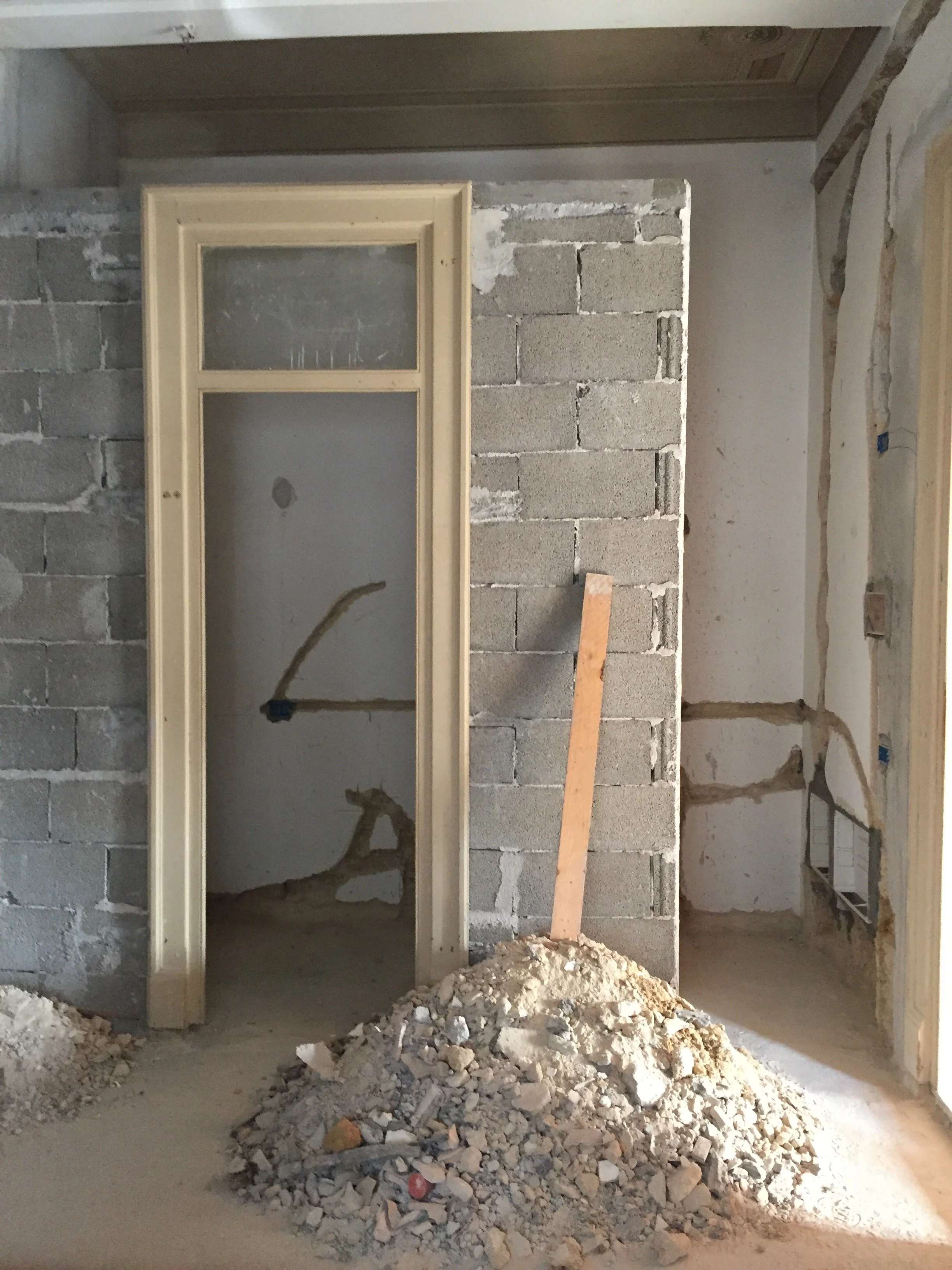 Costruzione del nuovo volume dei servizi durante il restauro di un appartamento storico a Palermo. L'immagine documenta la realizzazione del tramezzo che trasforma l'antico ingresso dell'abitazione, ricavando nuovi spazi funzionali destinati a bagno 