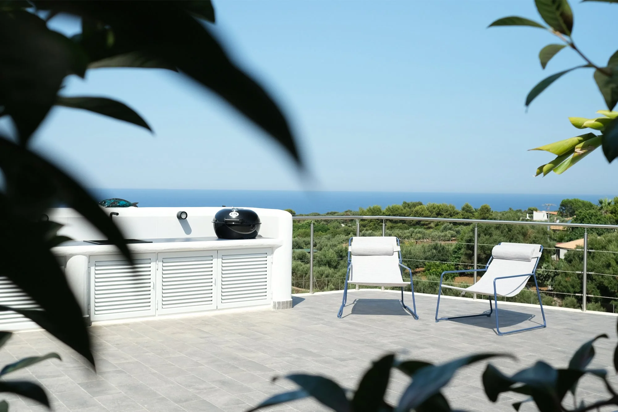Terrazza panoramica di villa a Ustica con vista sul mare Mediterraneo. La riqualificazione degli spazi esterni valorizza il rapporto tra architettura, paesaggio e orizzonte attraverso superfici essenziali e materiali contemporanei.
