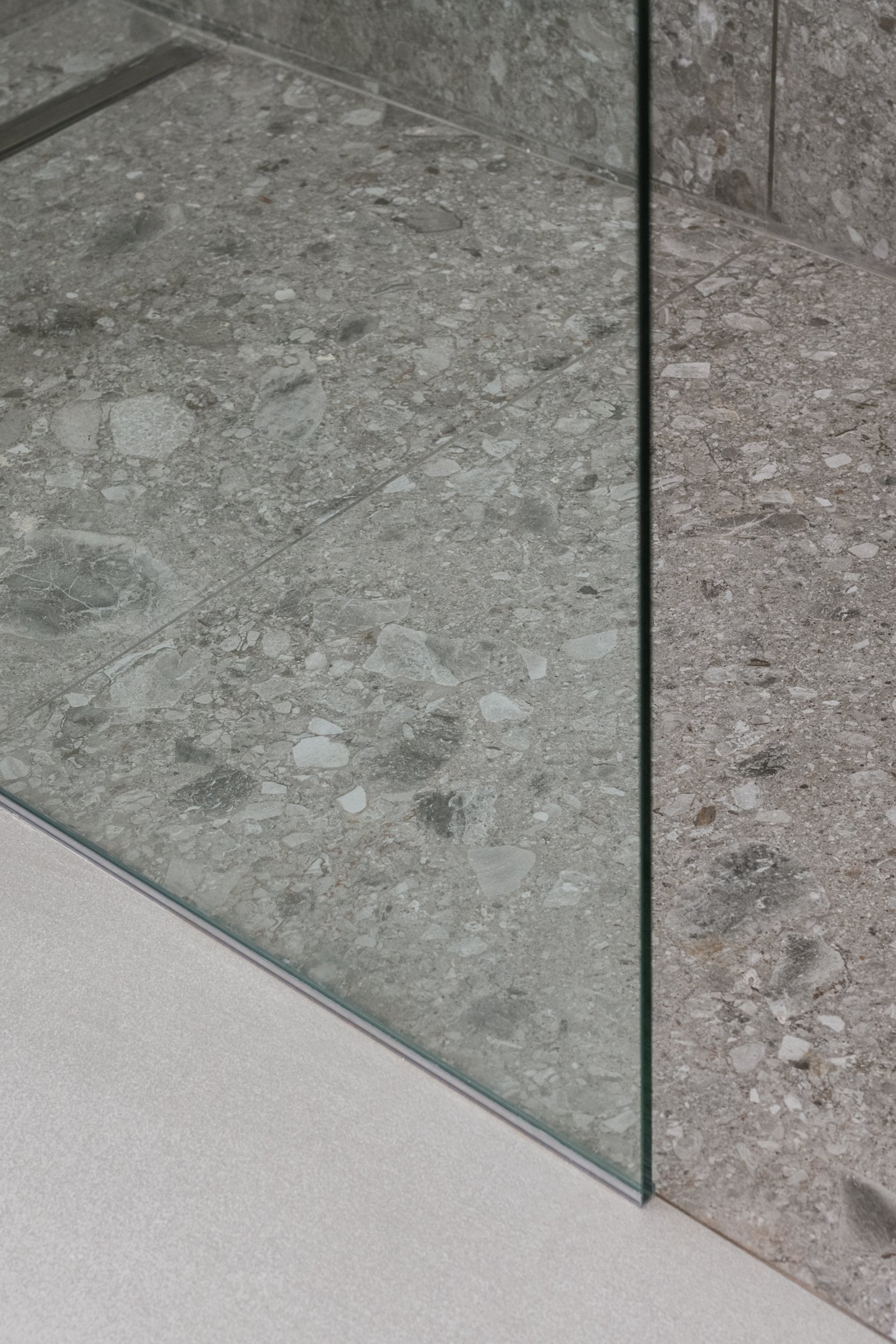 Doccia walk-in rivestita in gres porcellanato all'interno di una villa ristrutturata a Palermo. La nuova zona doccia interpreta il linguaggio essenziale del progetto Stilema. Francesco Di Raimondo Architetto ridisegna il bagno attraverso materiali co